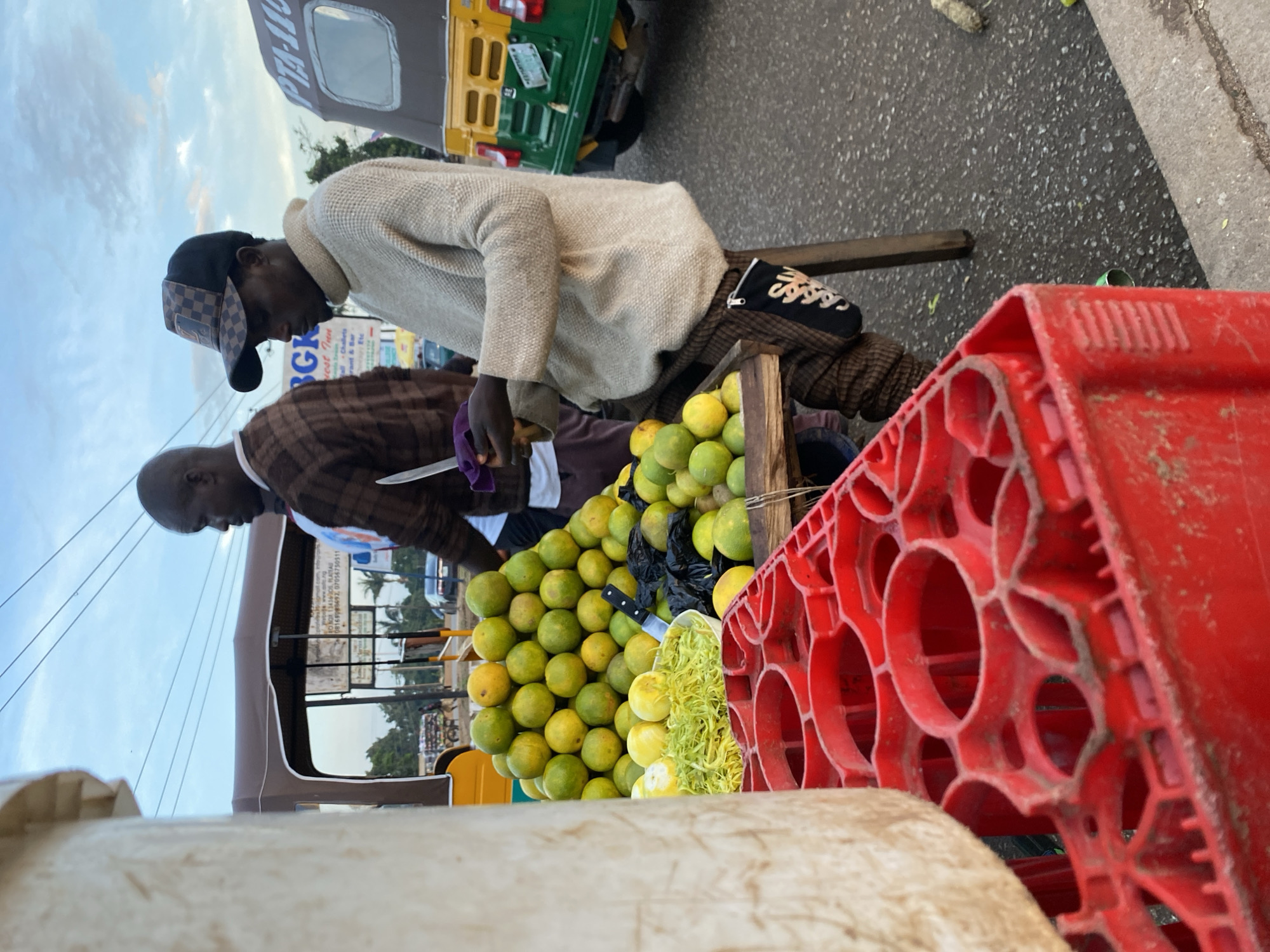 Bukuru street market buzzing with vendors and keke napeps at dusk