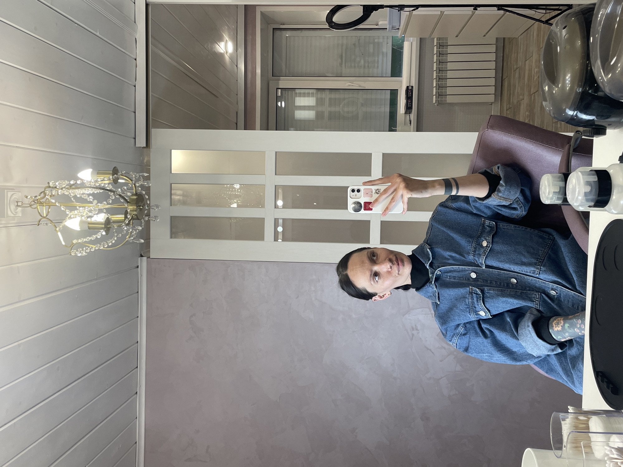 Woman takes mirror selfie at beauty salon in Izhevsk
