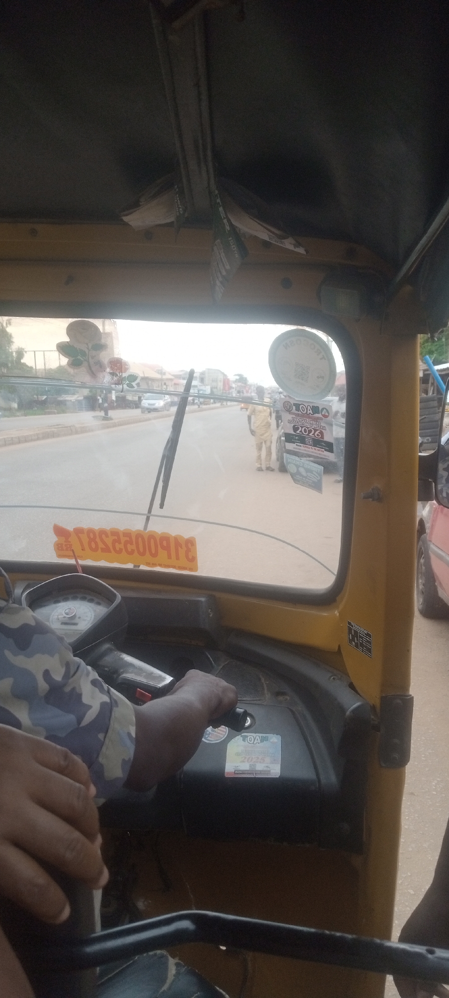 Passenger rides keke tricycle through Sabon Tasha, Nigeria