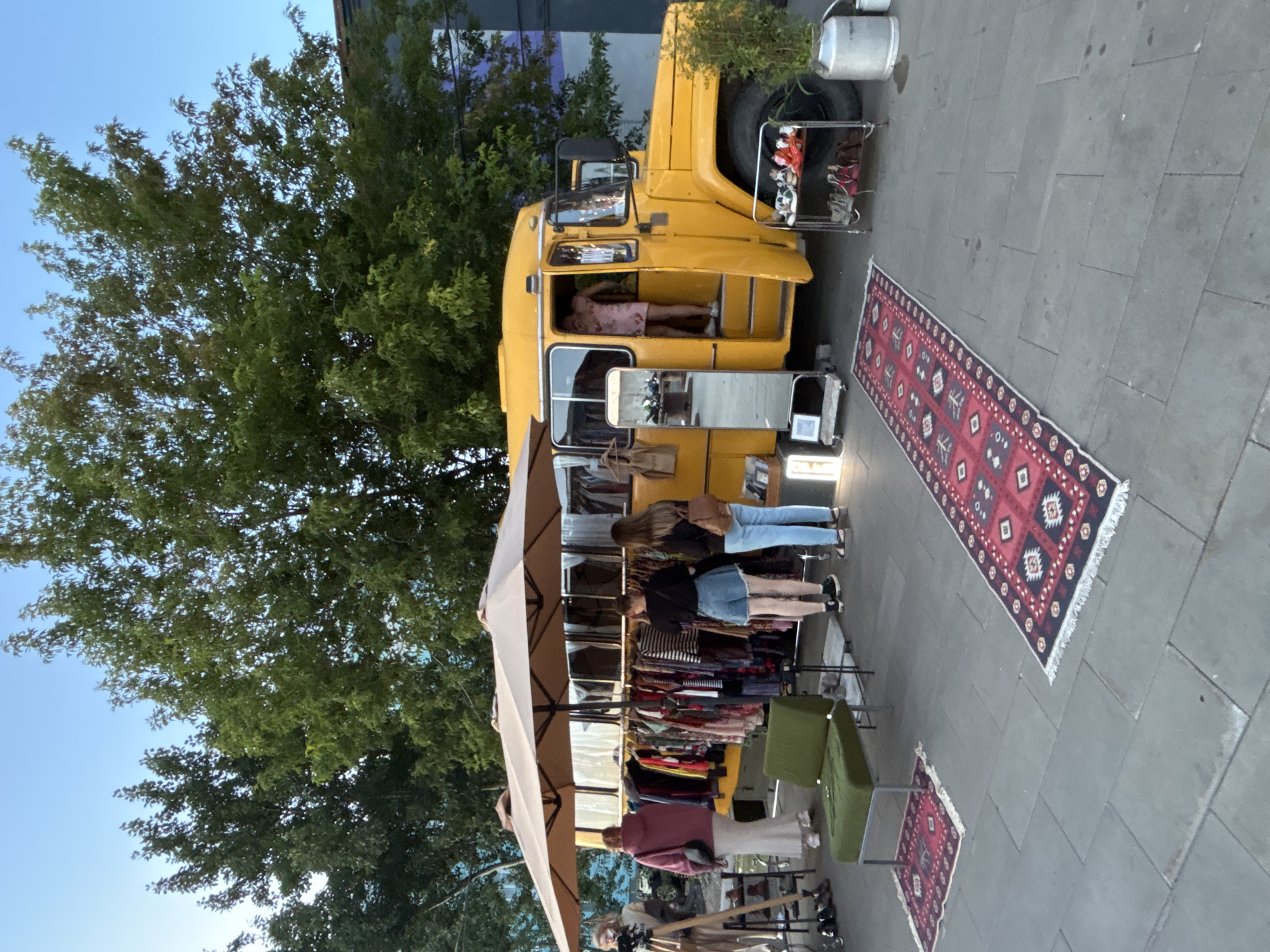 Pop-up clothing market by a converted yellow bus, Saint Petersburg