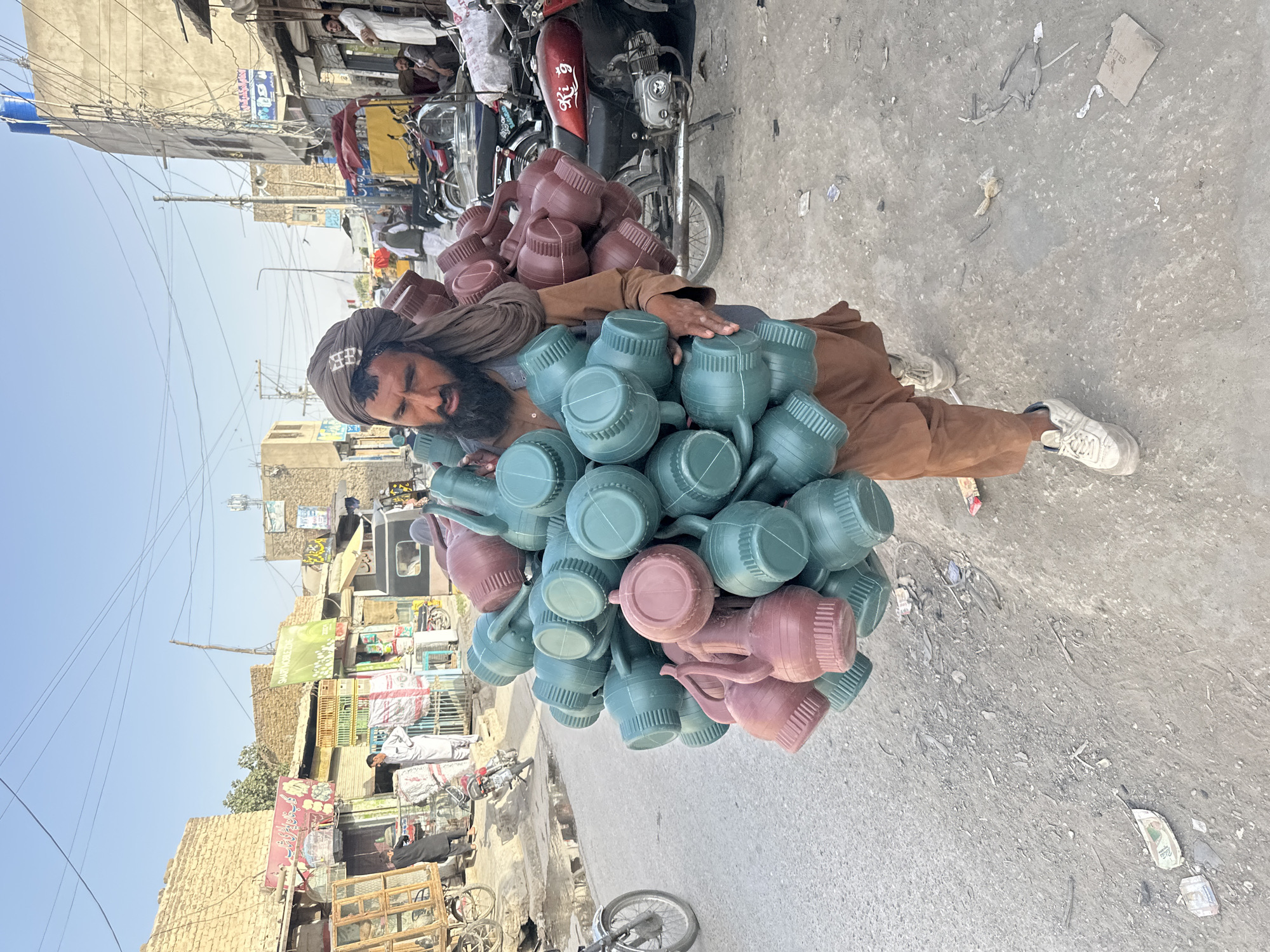 Bundle of plastic jugs carried through dusty Quetta street