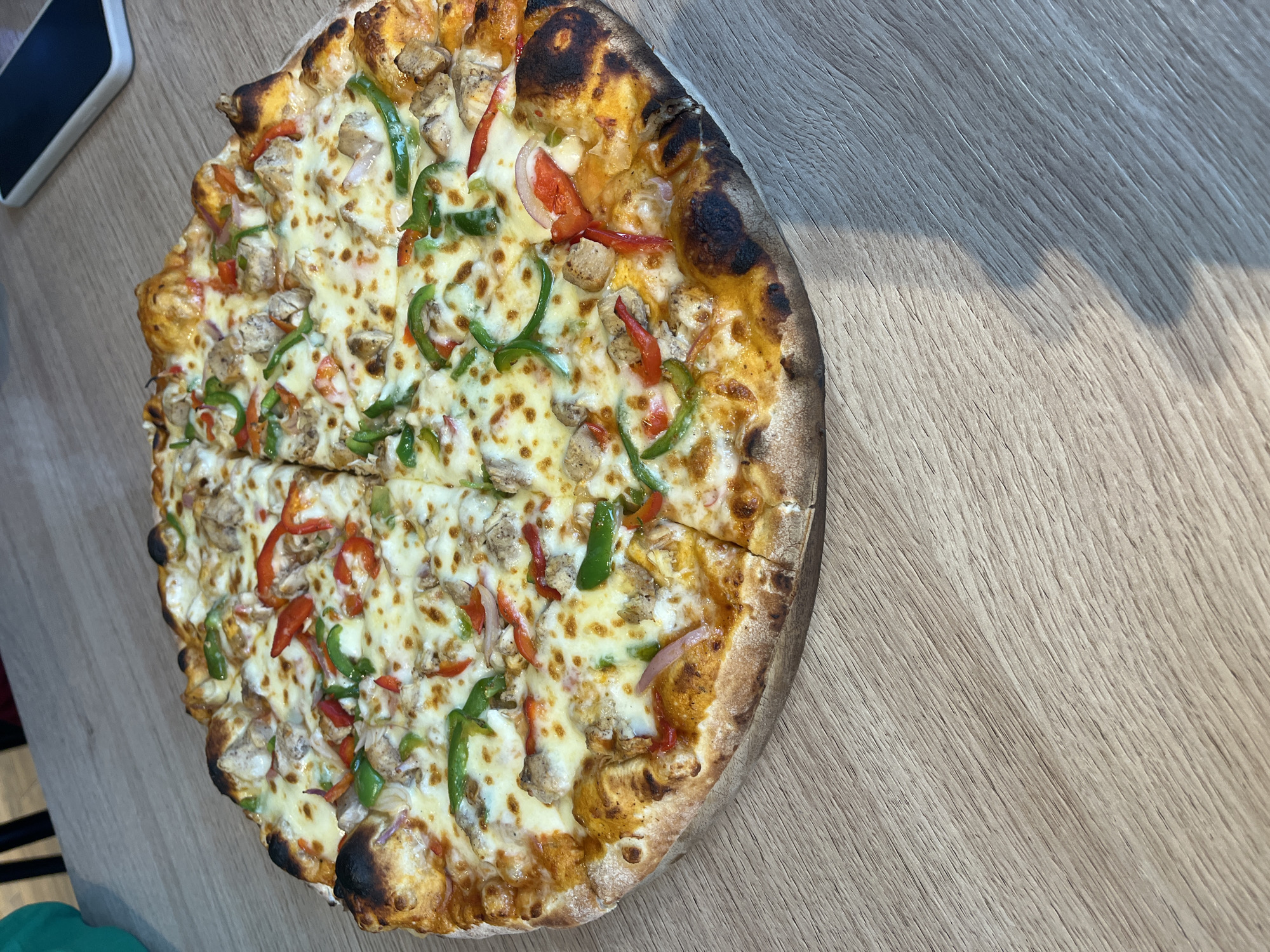 Two women share pizza at Abuja restaurant