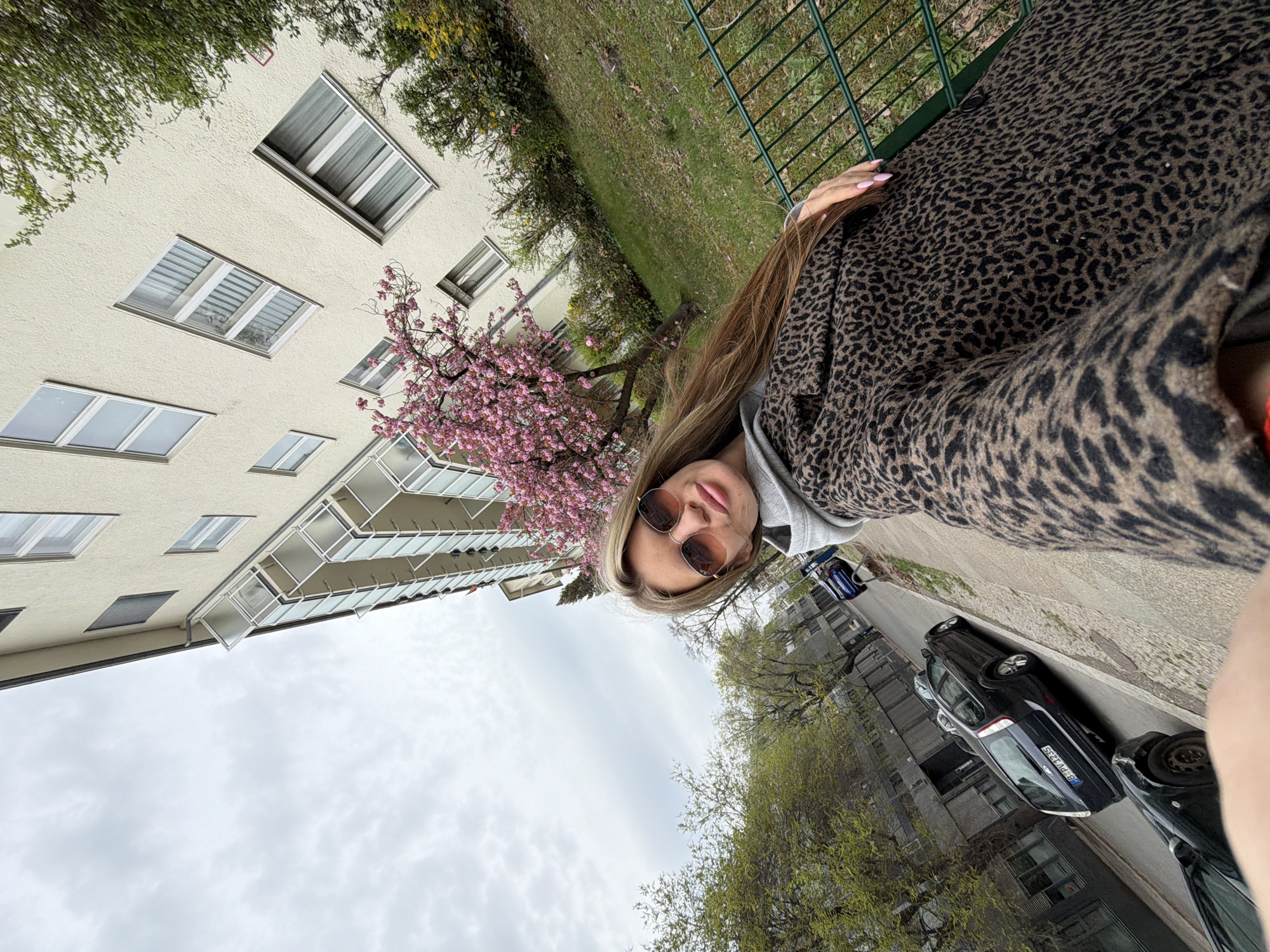 Woman in leopard coat takes selfies on Berlin street
