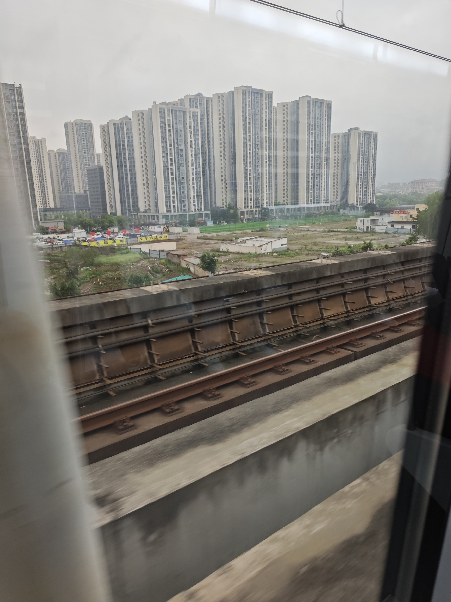 Train passenger photographs Chongqing apartment towers from window