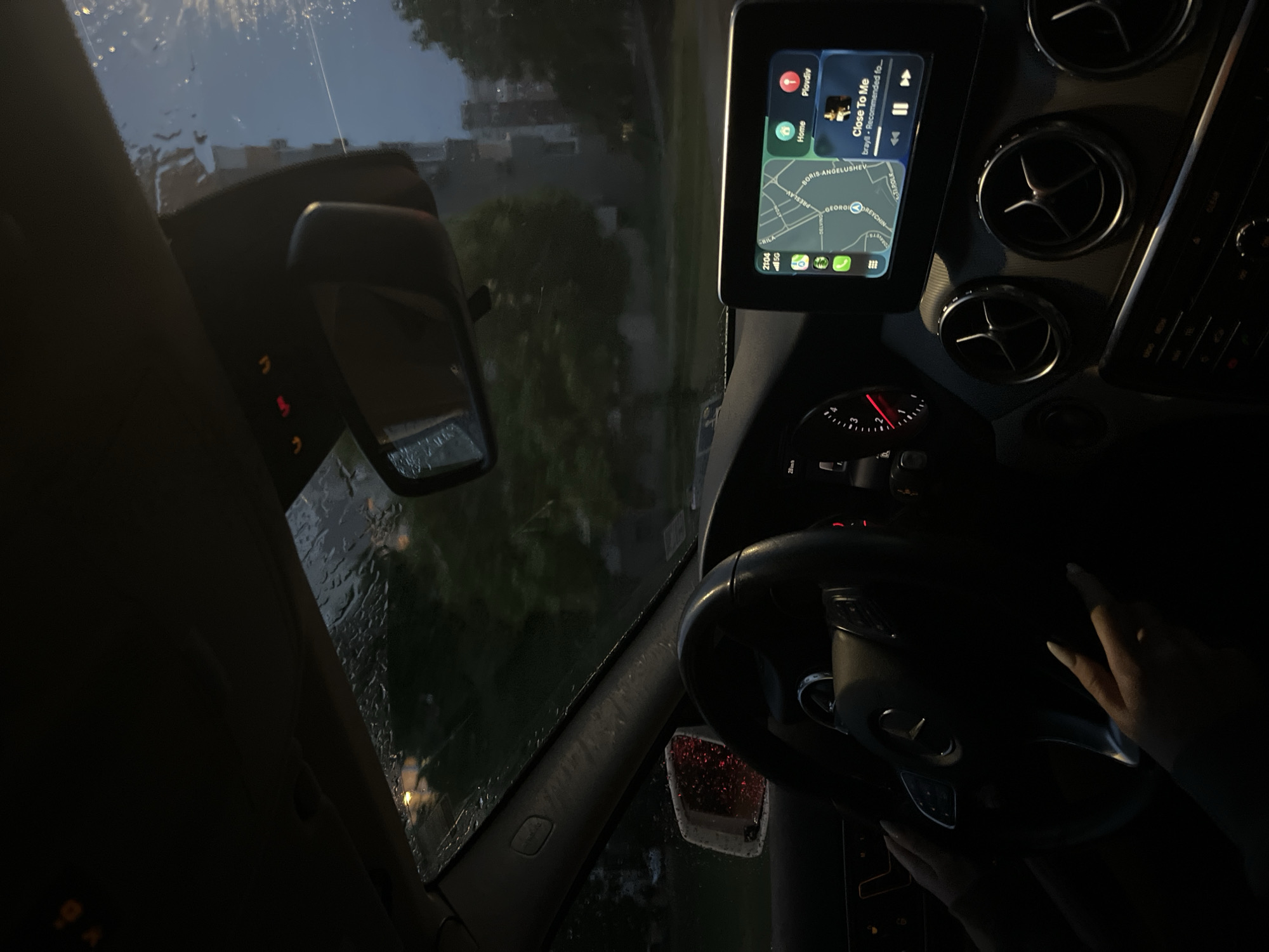 Driver navigates rainy evening streets in Blagoevgrad, Bulgaria