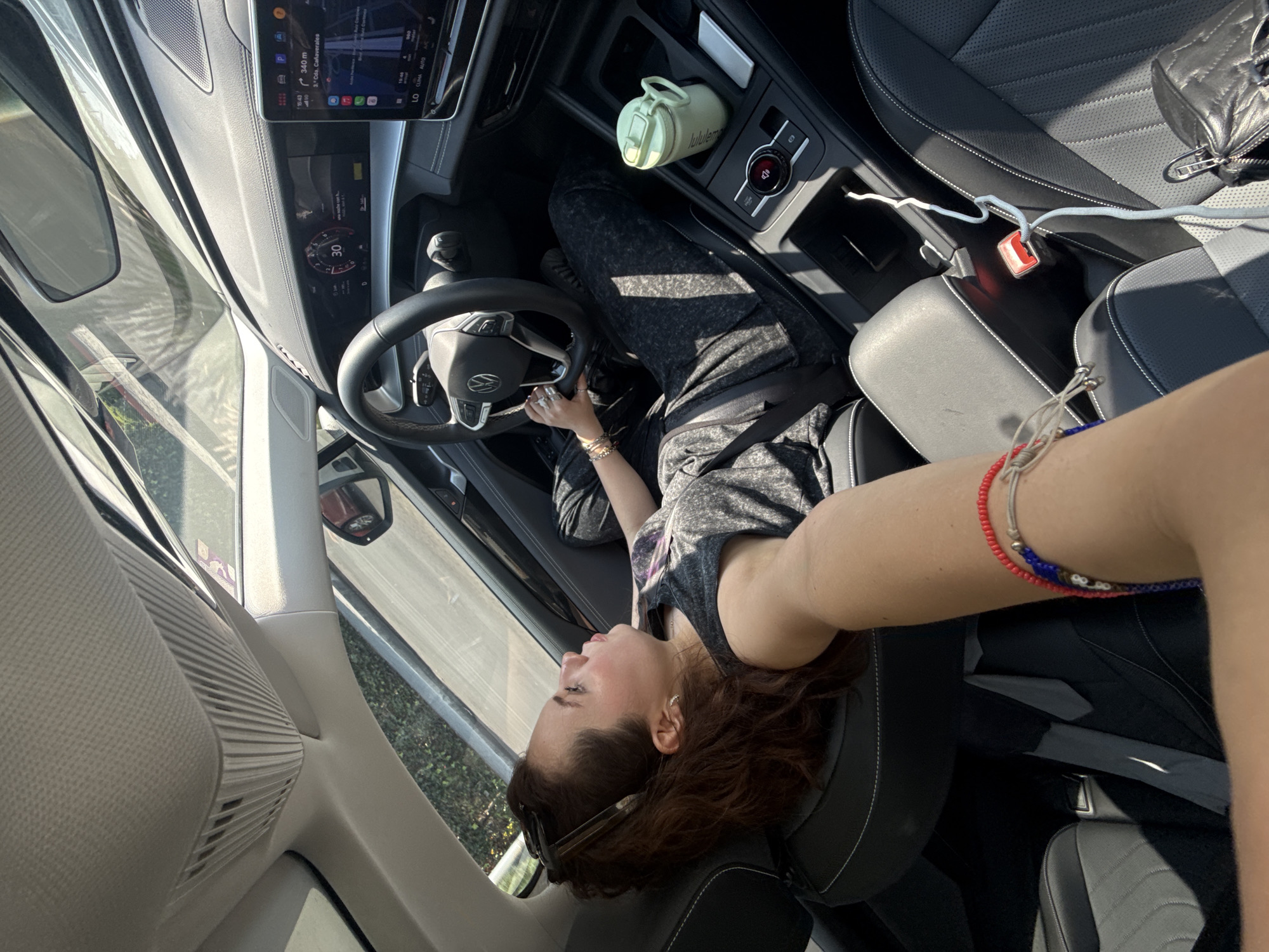 Woman takes selfie in car with Spanish navigation display
