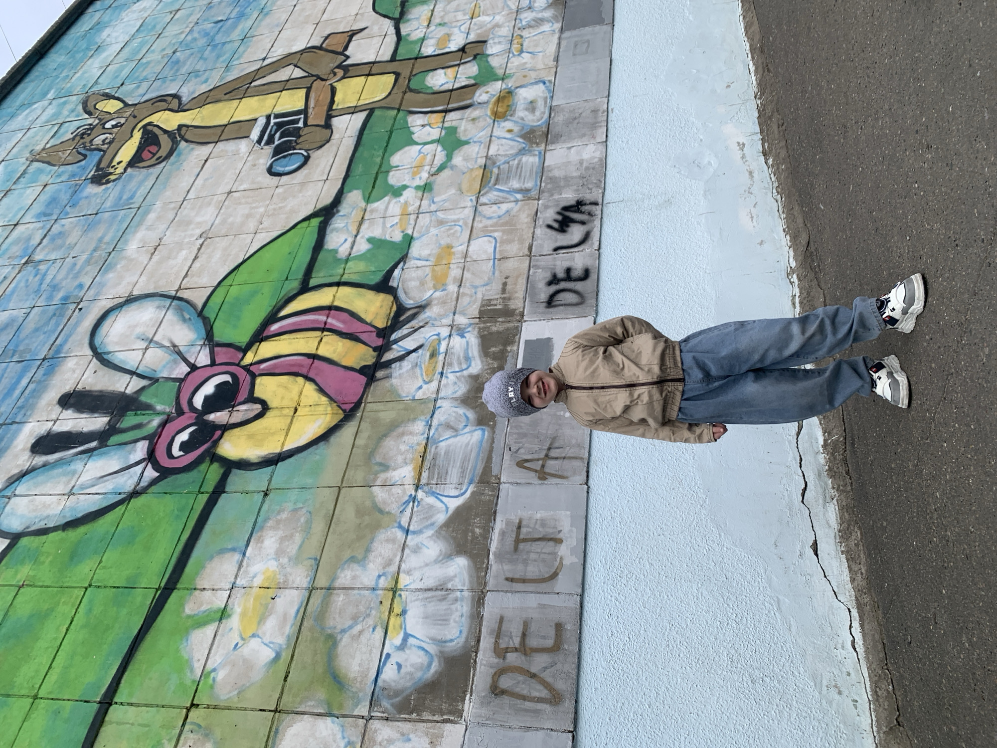 Child poses at cartoon mural in Severodvinsk, Russia