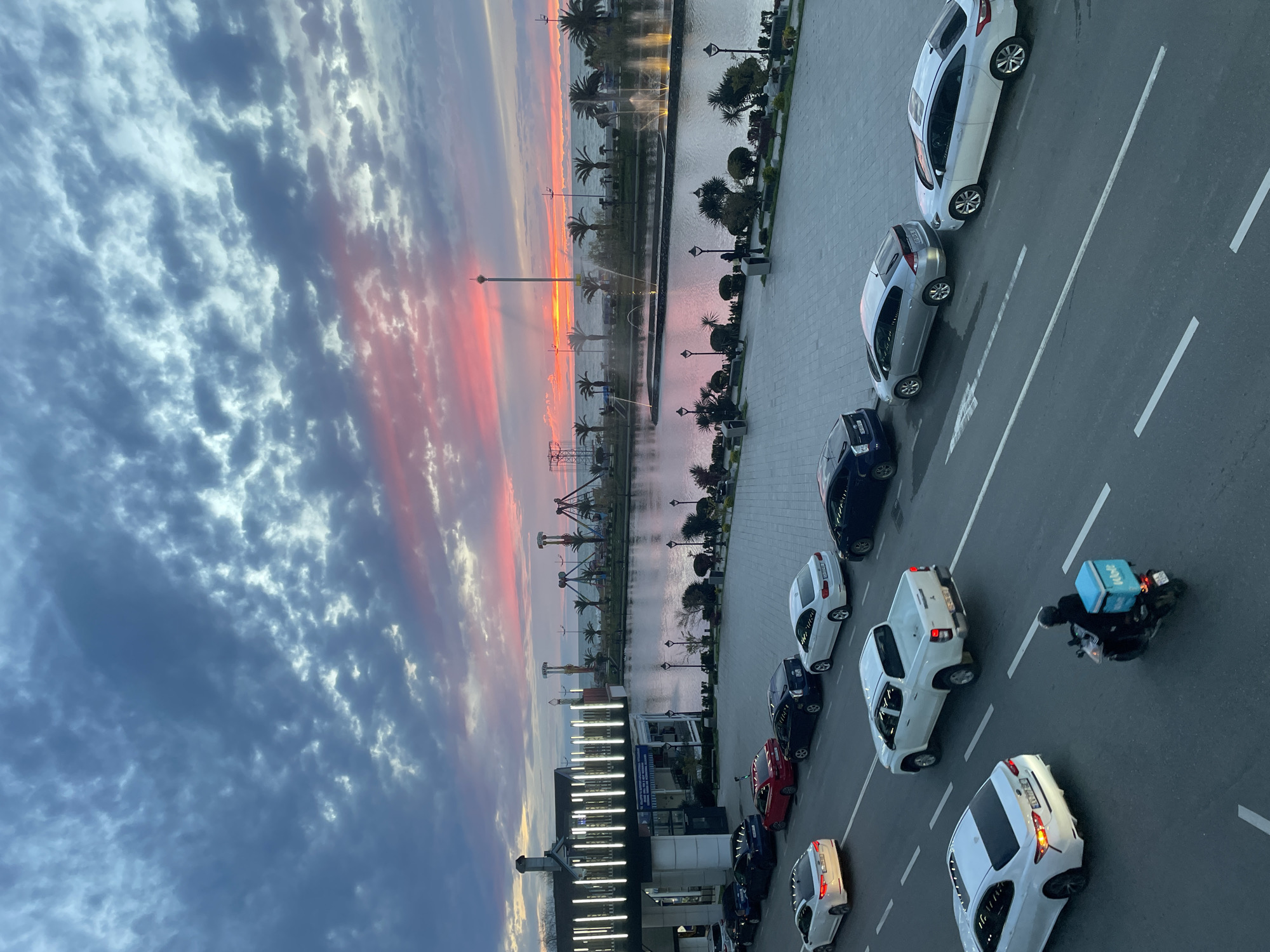 Elevated view captures Batumi waterfront street scene with parked cars