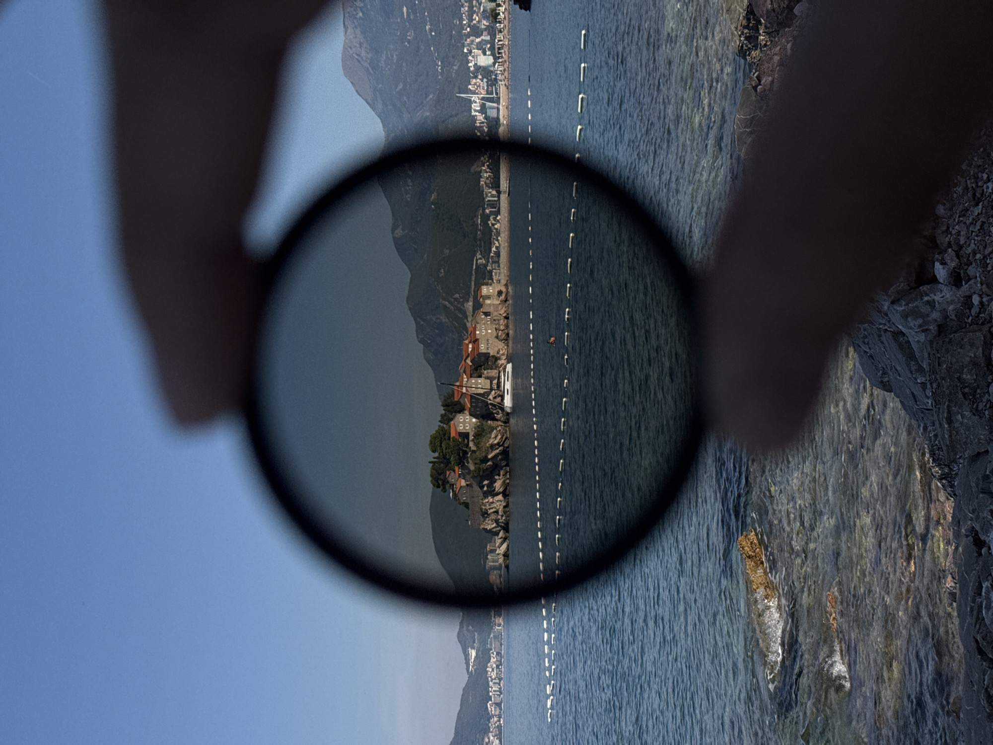 Sveti Stefan's stone islet framed from the shore, sunny morning