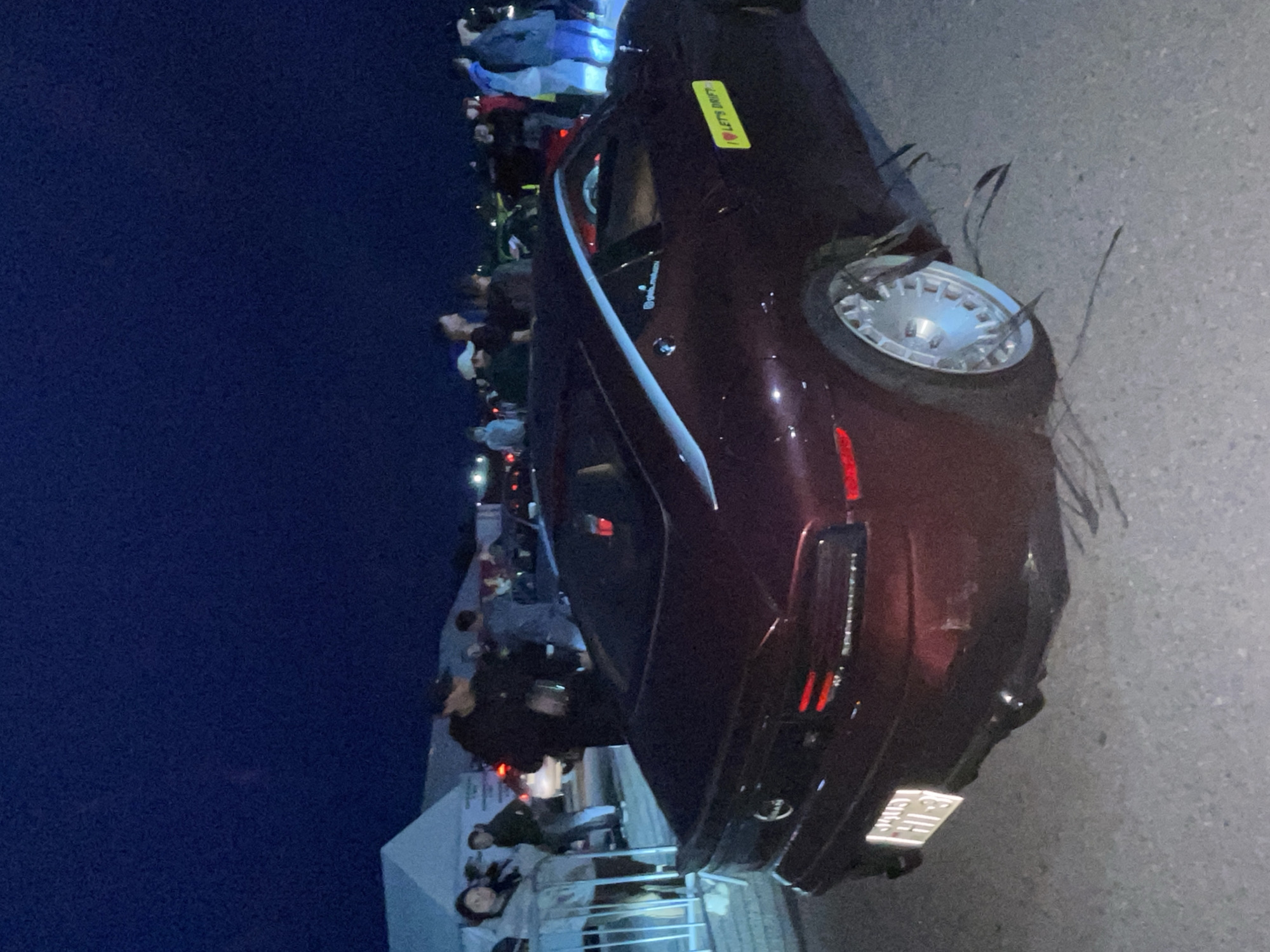 Nighttime drift event: track action, crowd, and car damage