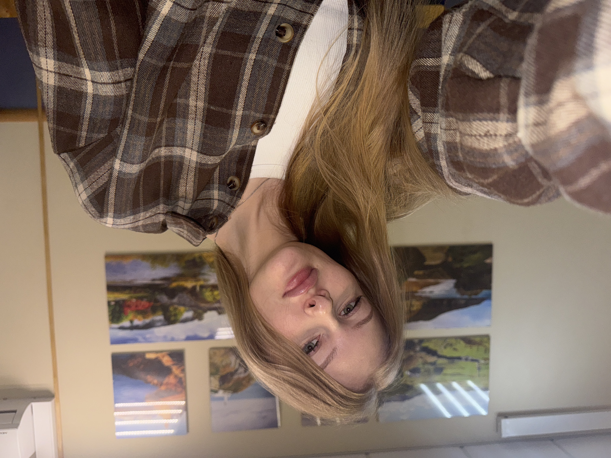 Woman takes selfies in plaid shirt in Perm apartment