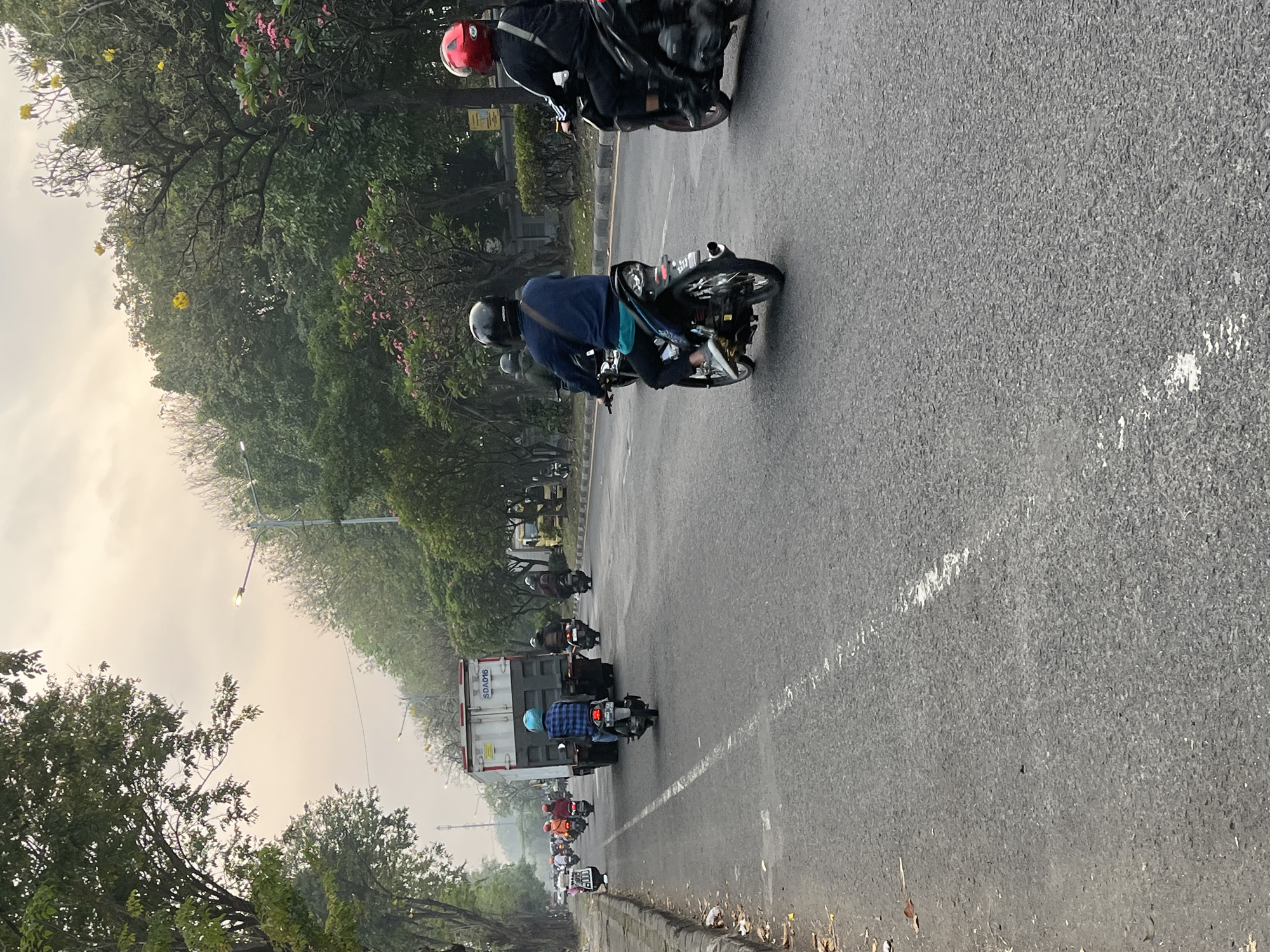 Motorcycle traffic flows through hazy streets of East Java