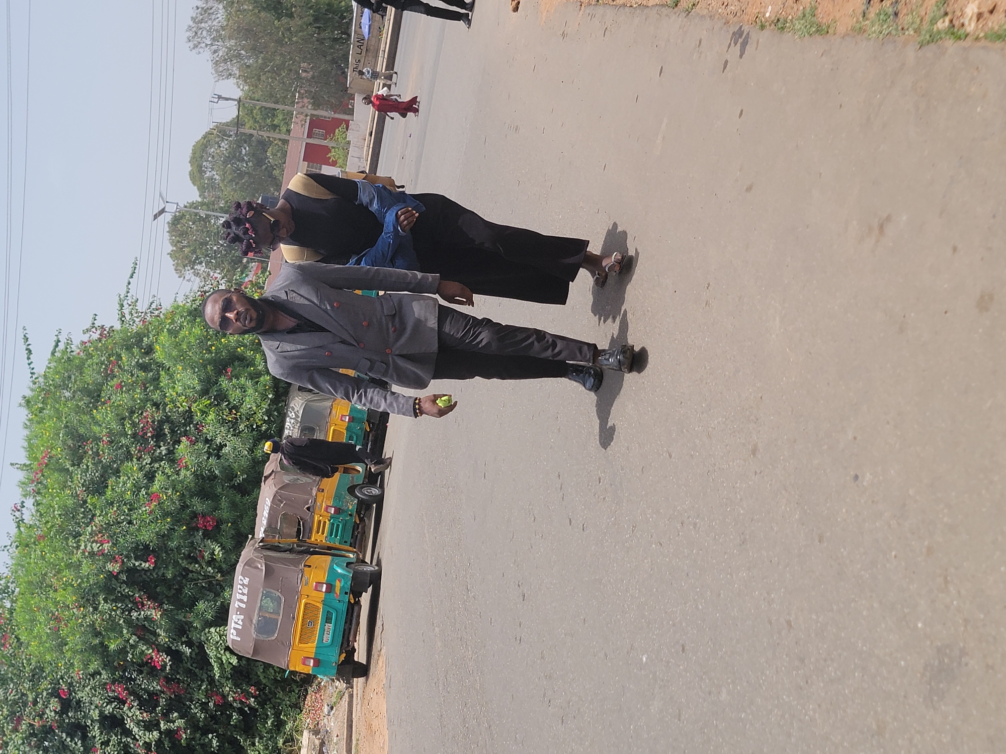 Two men walk along road in Jos, Nigeria