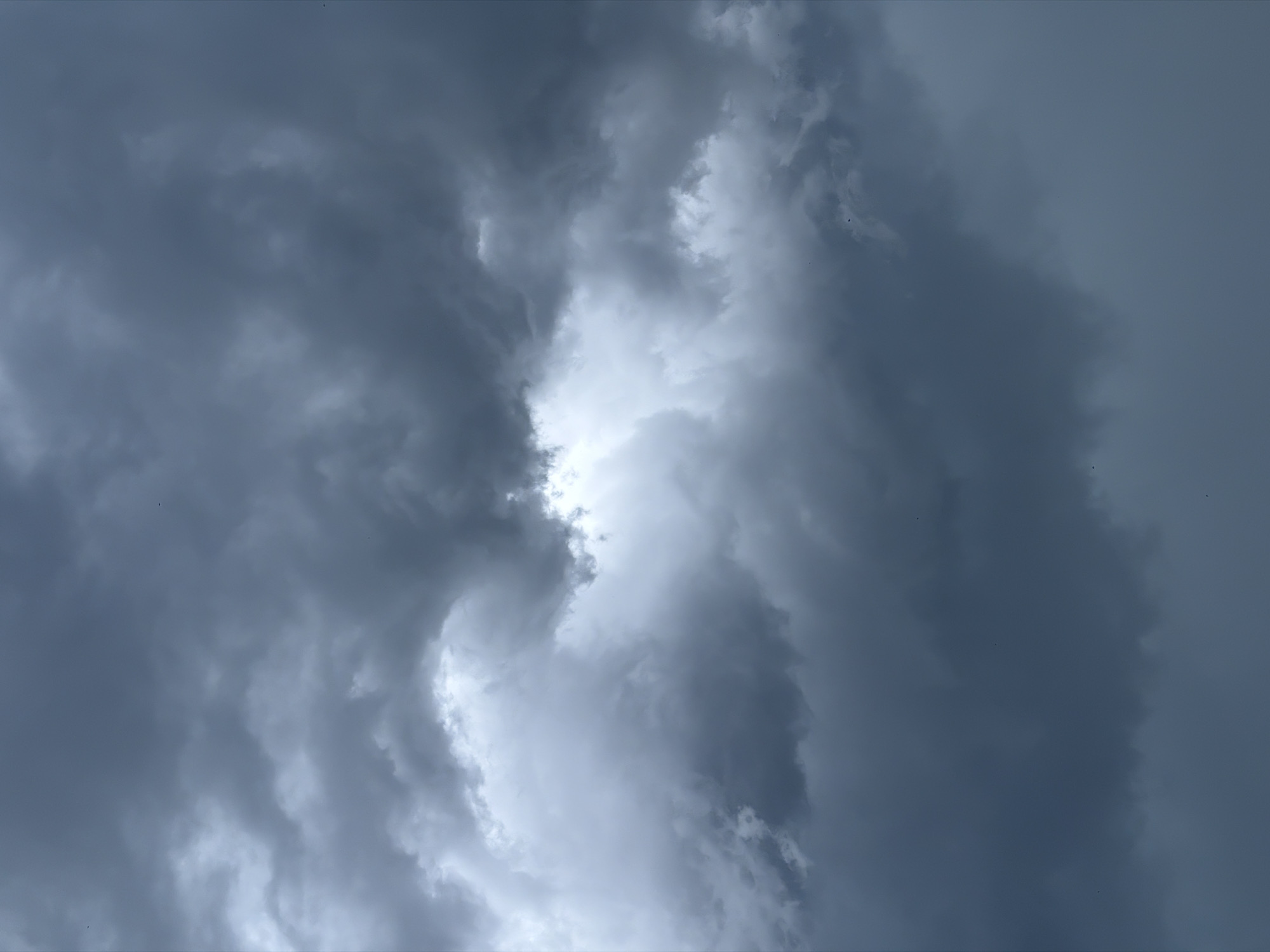 Dark storm clouds gather over a rooftop in an unknown city