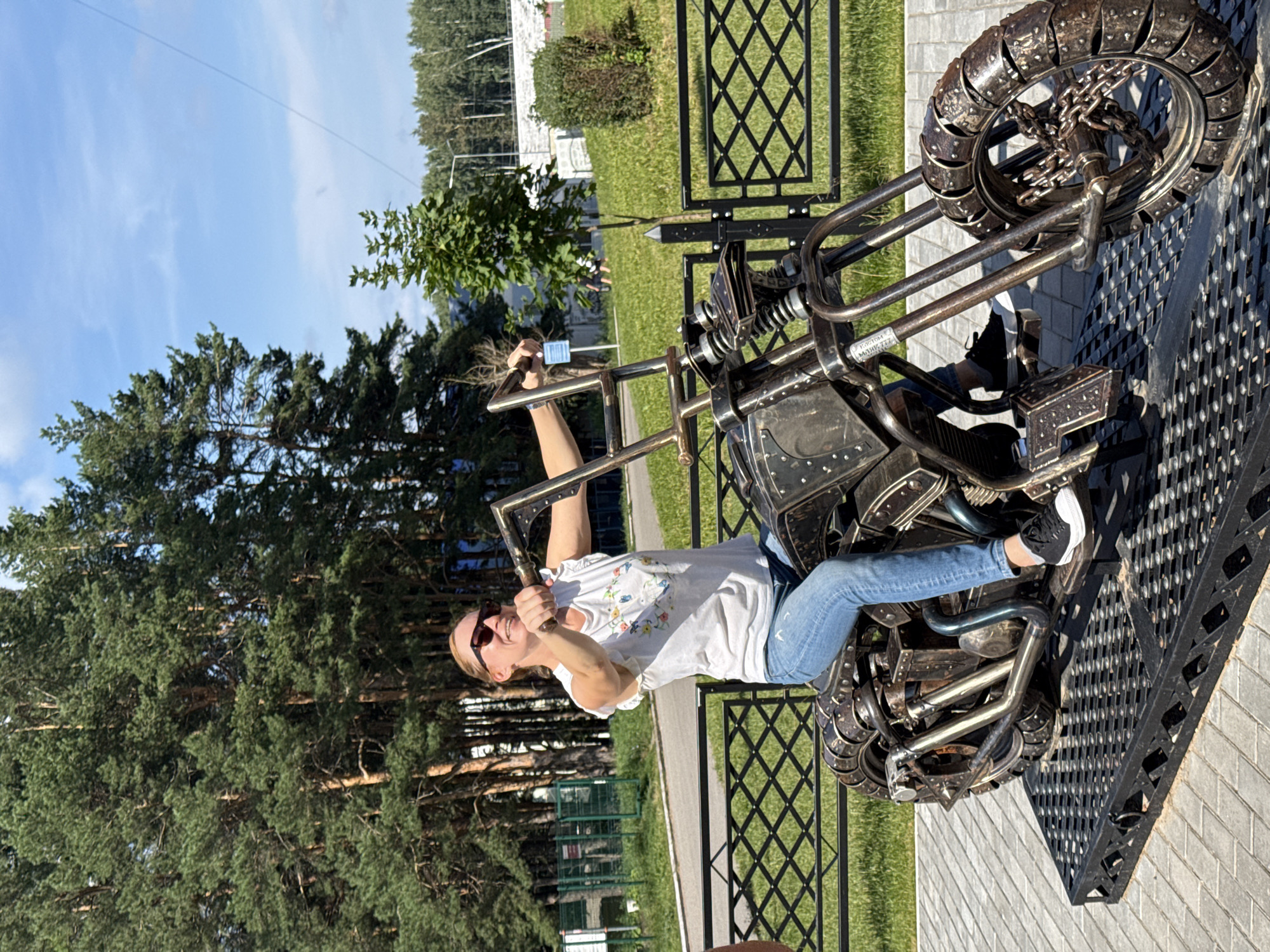 Posing on a metal motorcycle sculpture in Chaikovsky
