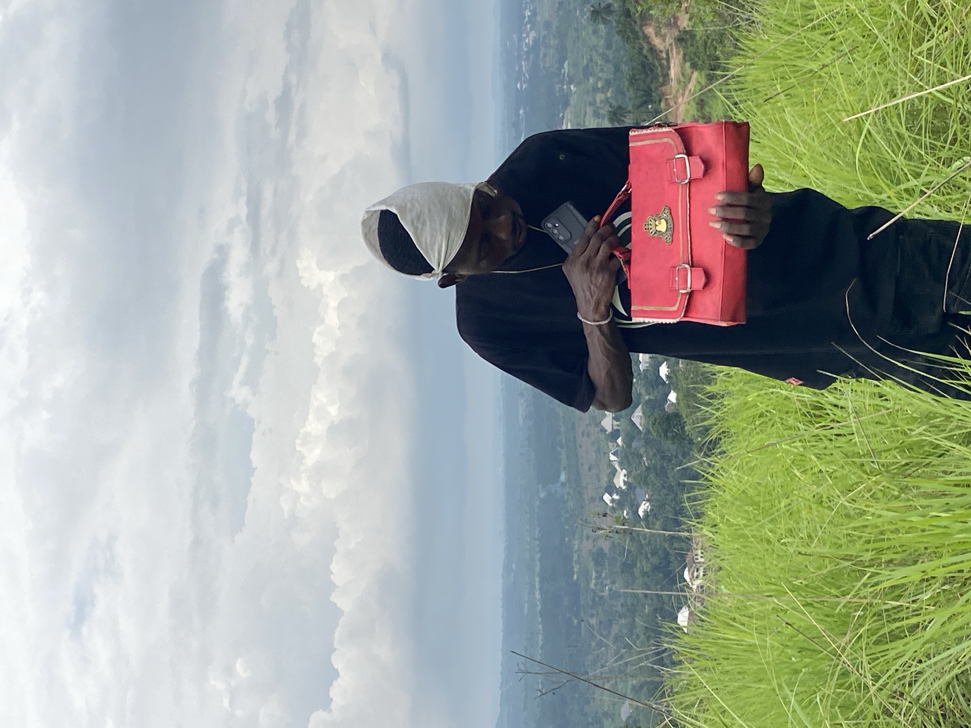 Person with red bag observed on hillside in Achara, Nigeria