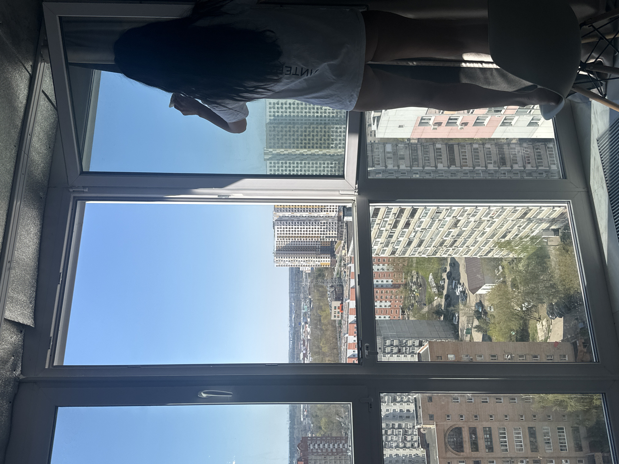 Person gazes from high-rise window in Отрадное, Russia