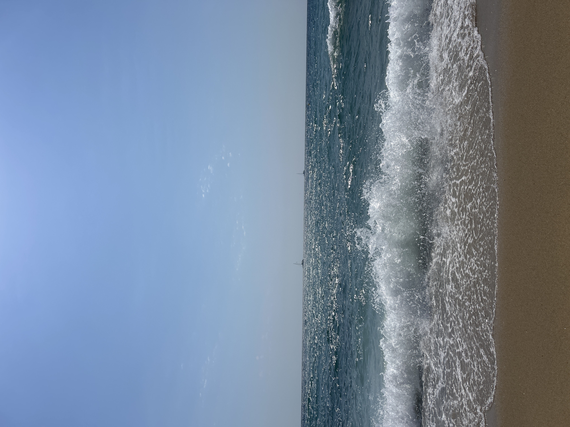 Barcelona beach morning: waves, sailboats, and a passing helicopter