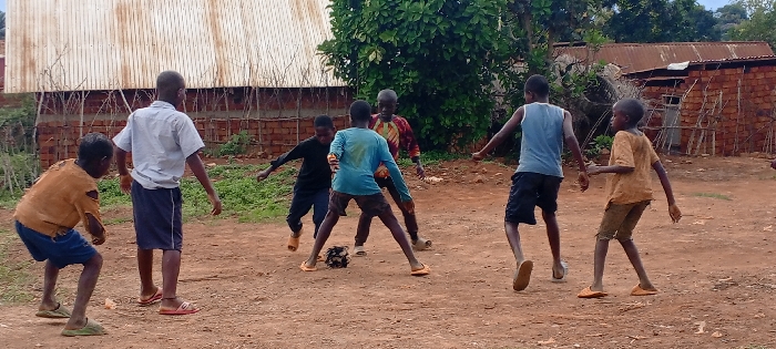 Children play football on dirt fields in DR Congo