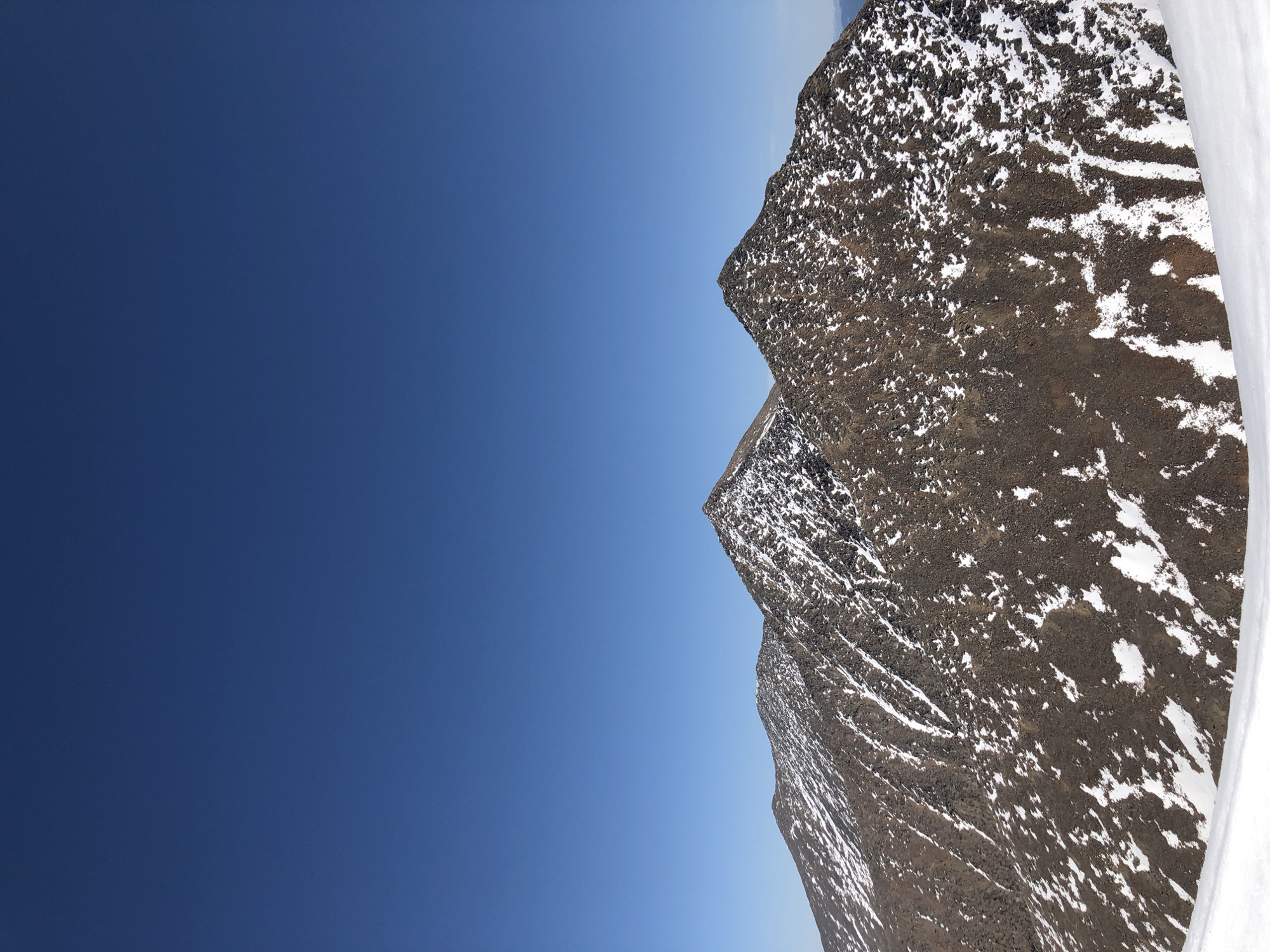 Snow-capped mountains observed under clear blue skies in Russia