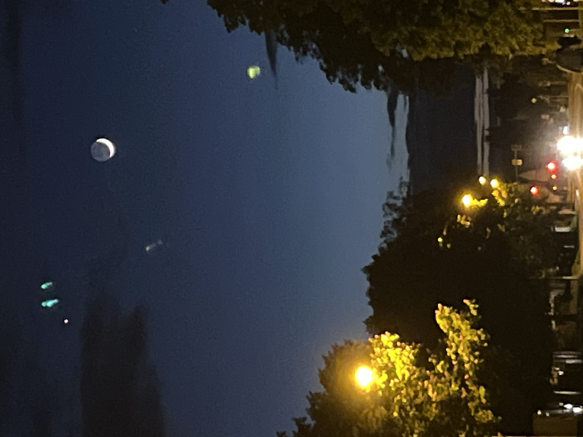 Crescent moon and bright celestial object observed in urban sky