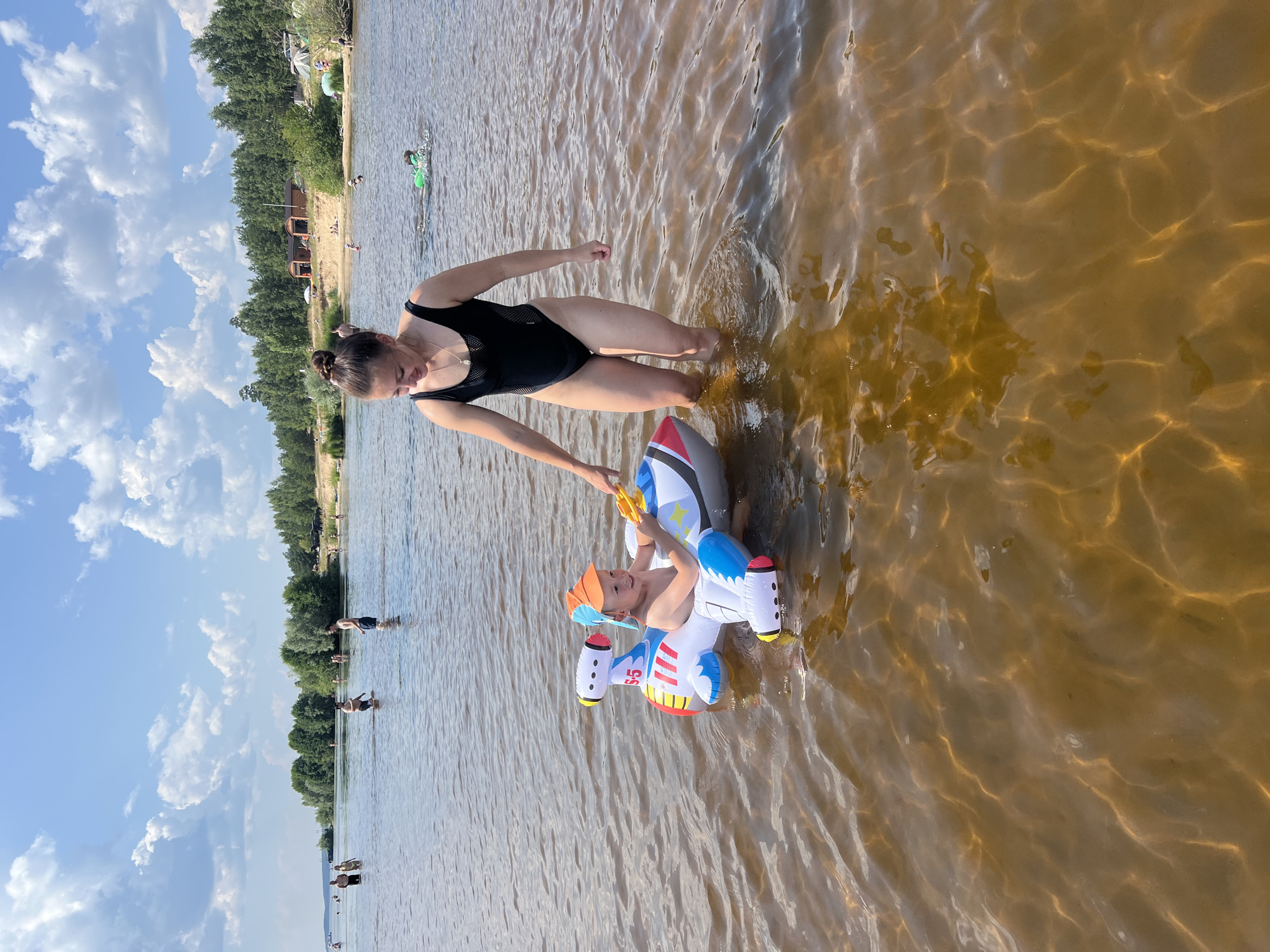Sunny summer day at a Russian lakeside beach with inflatable toys