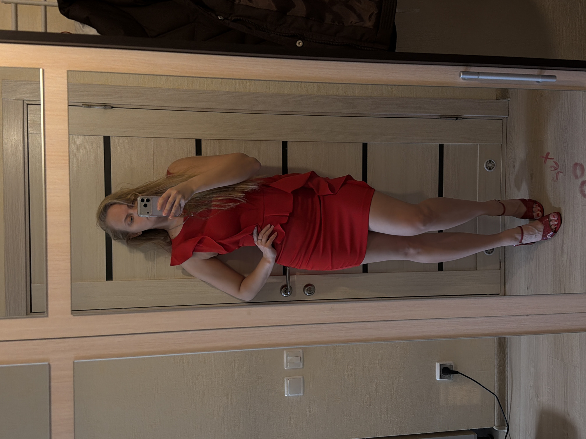 Woman takes mirror selfies in red dress in Izhevsk
