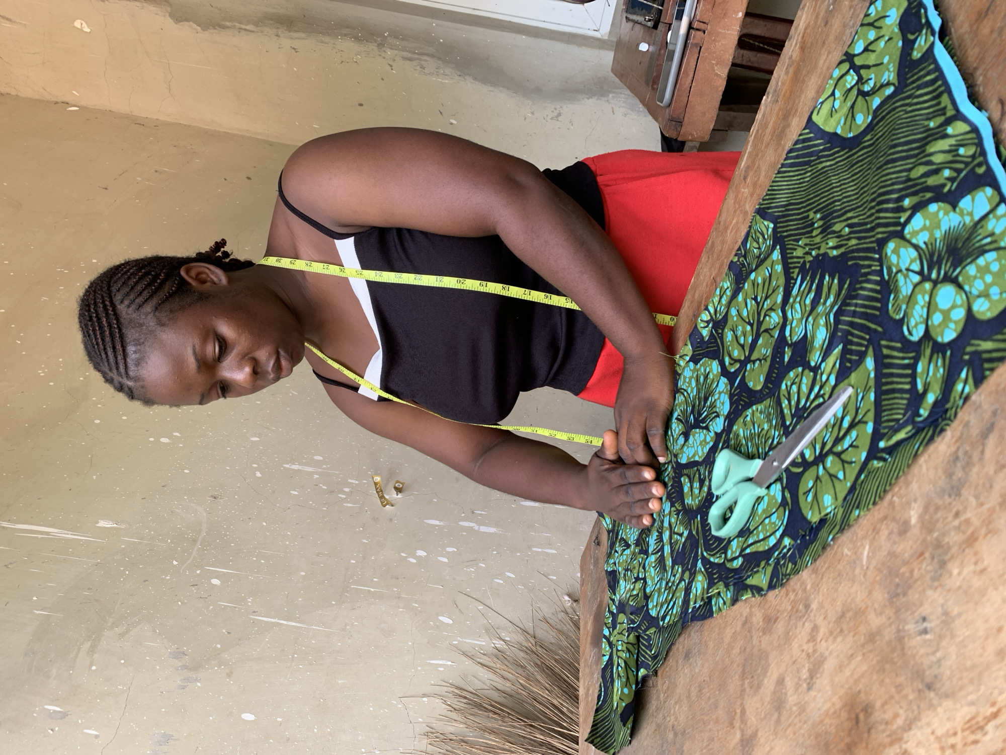 Measuring and sewing patterned fabric at a workshop in Akwanga