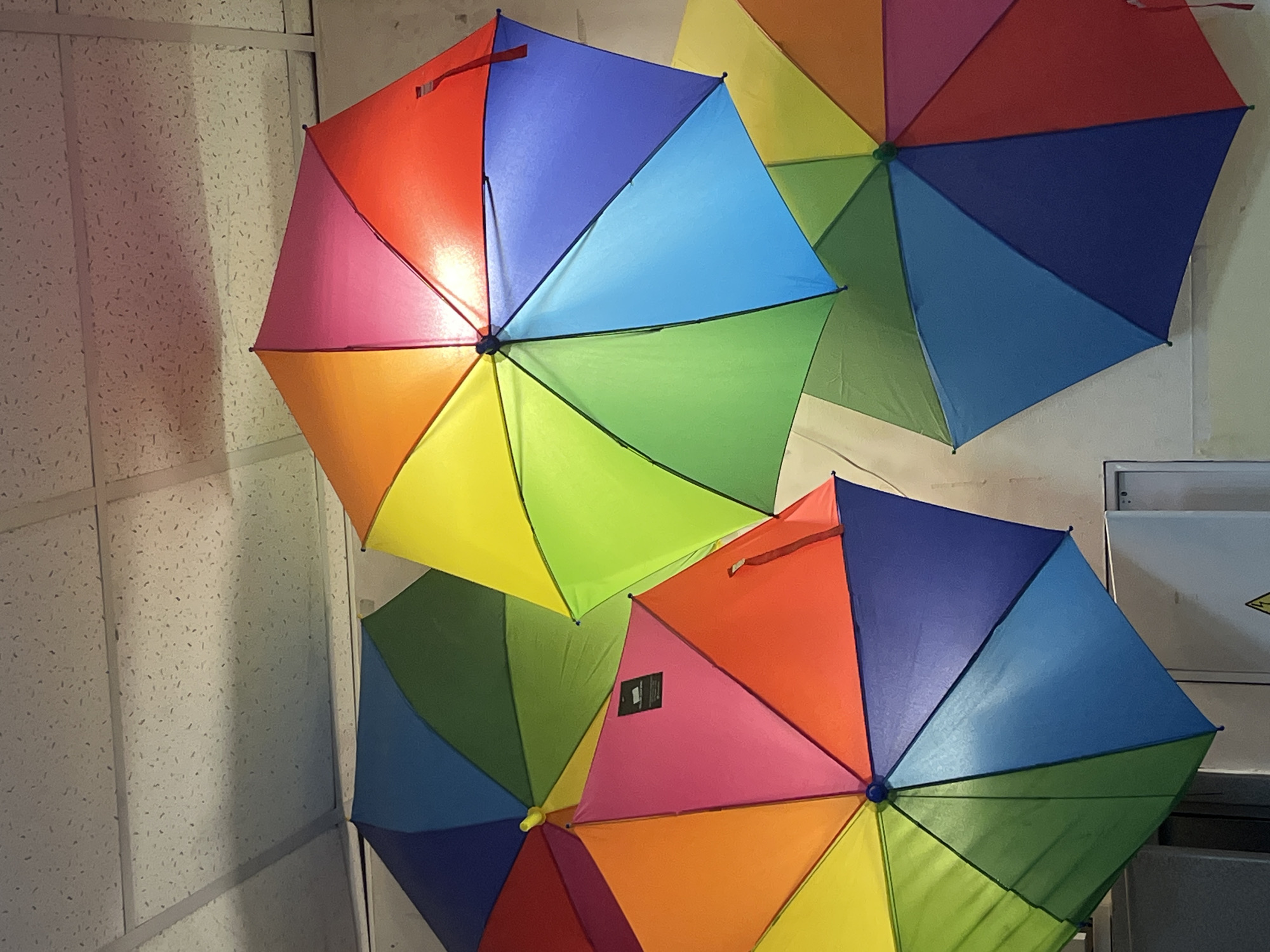 Rainbow umbrellas clustered indoors in Izhevsk, Russia