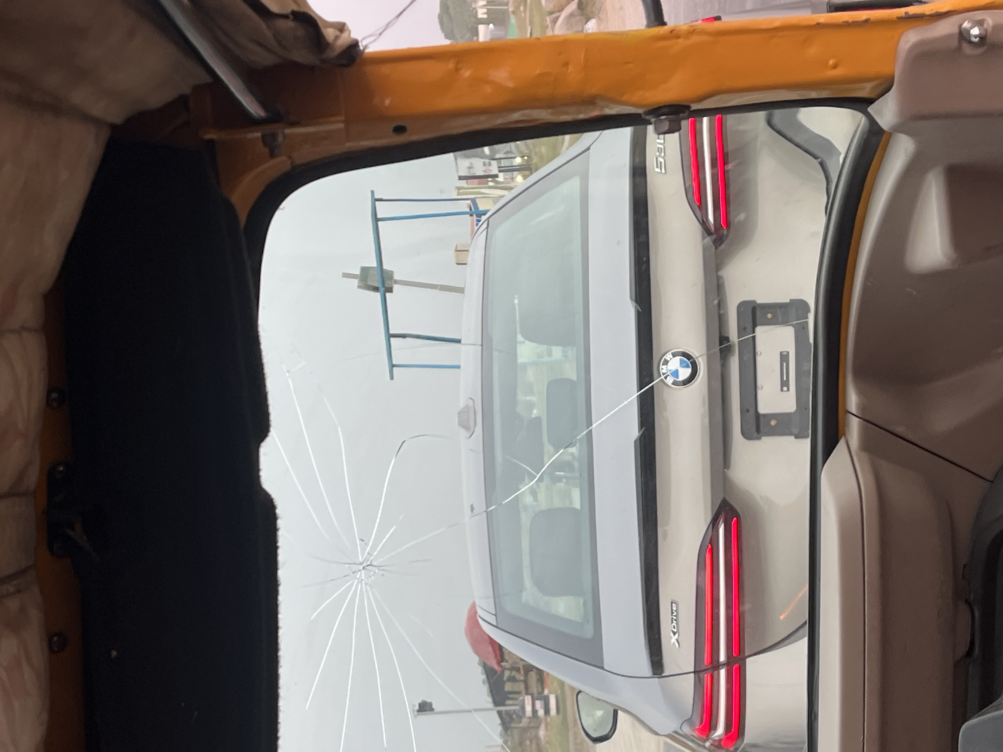 Rickshaw passenger captures cracked-window street view in Karum