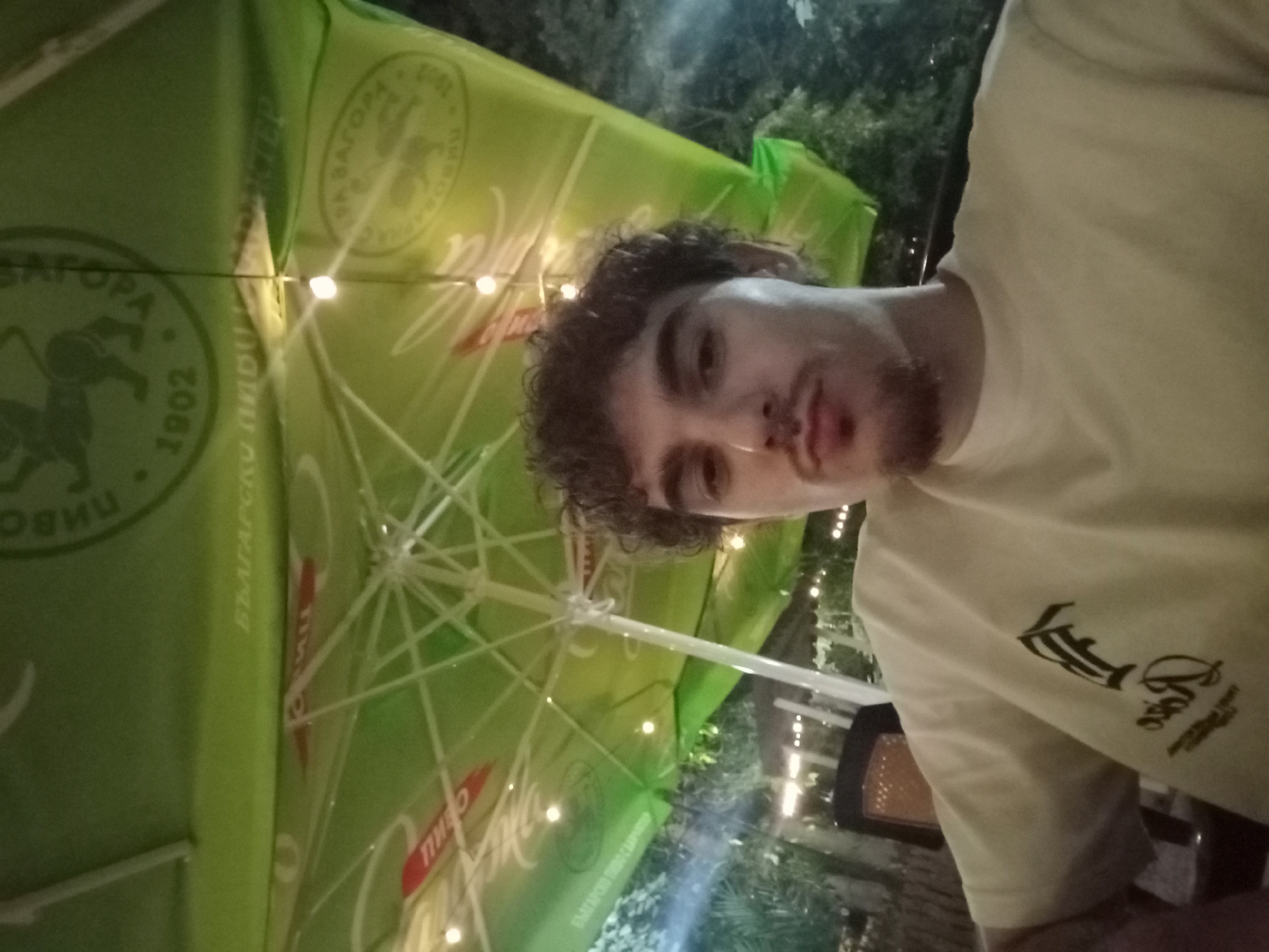 Young men gather at nighttime cafe in Parvomay, Bulgaria