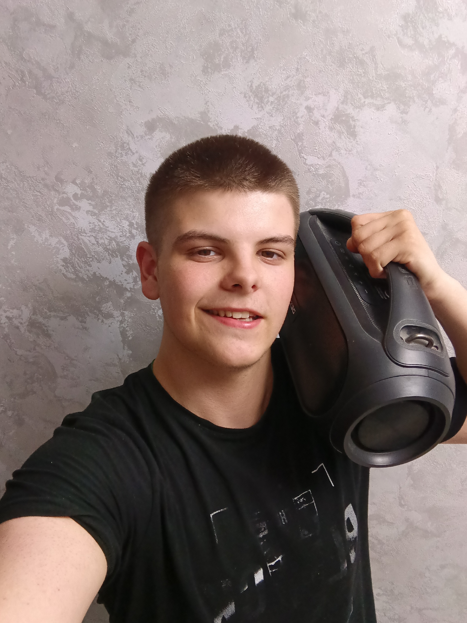 Young man poses with speaker and walkie-talkie equipment