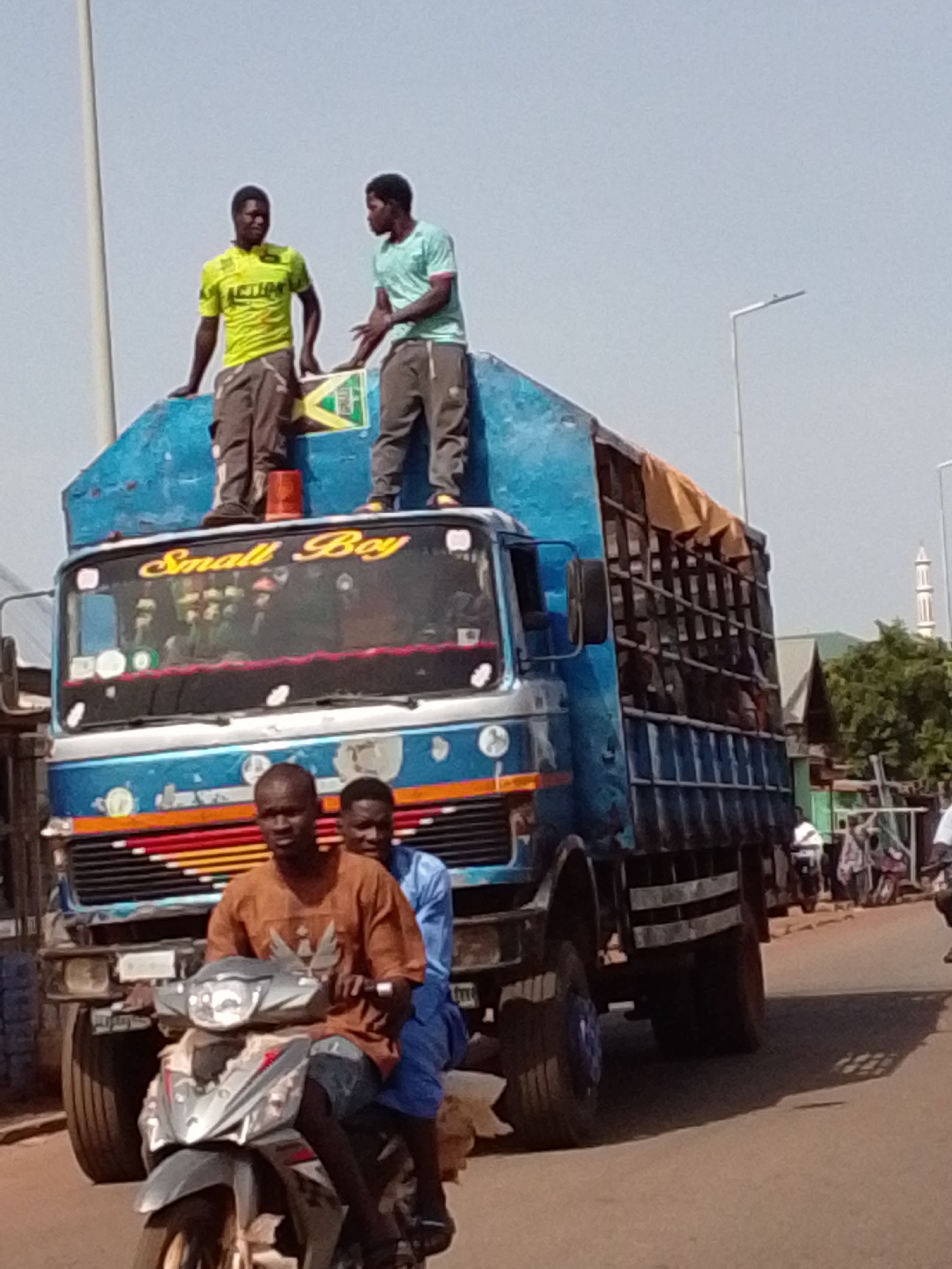 Two men stand atop truck in Tamale, Ghana