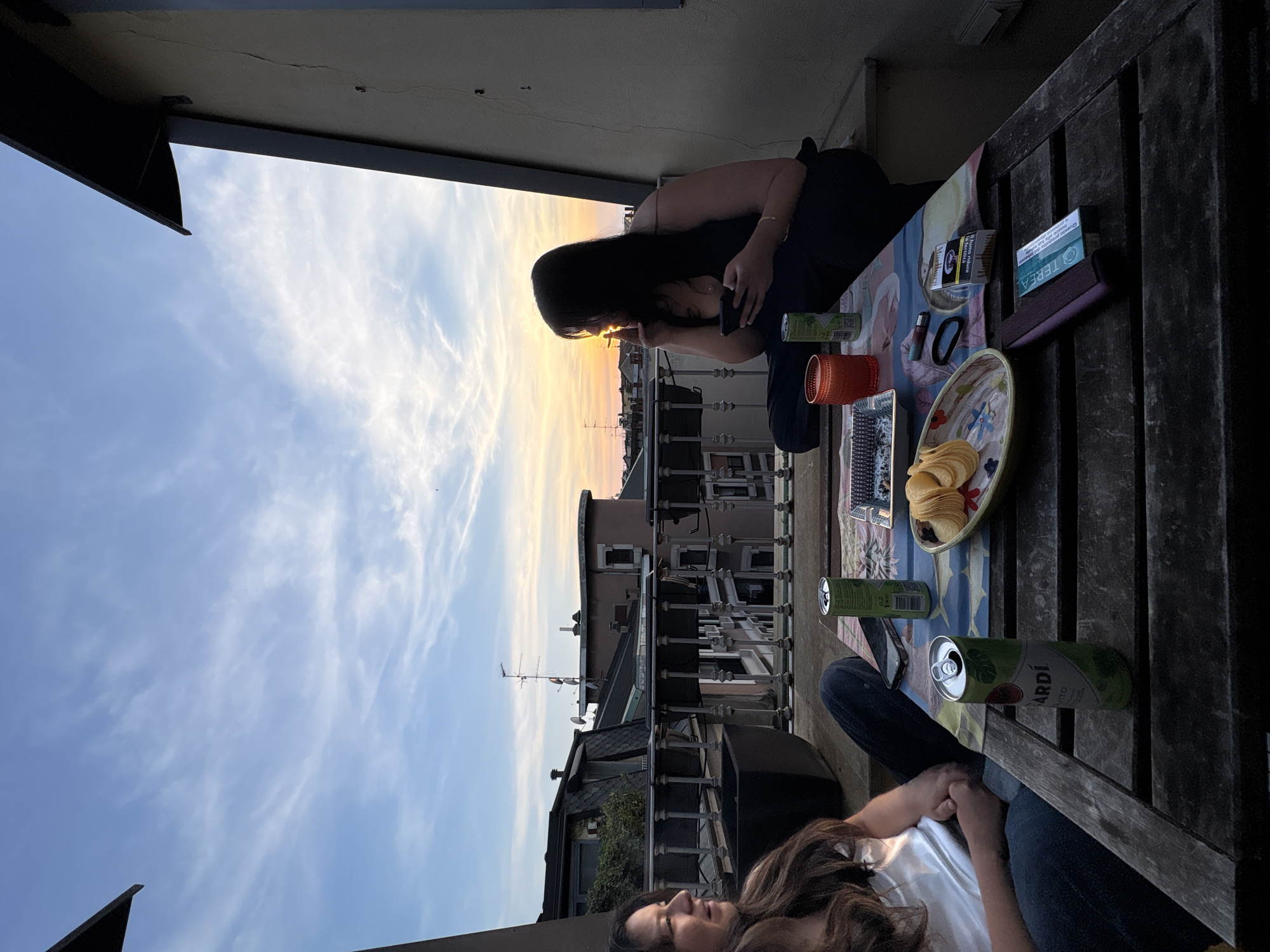 Two women enjoy sunset from Milan rooftop terrace
