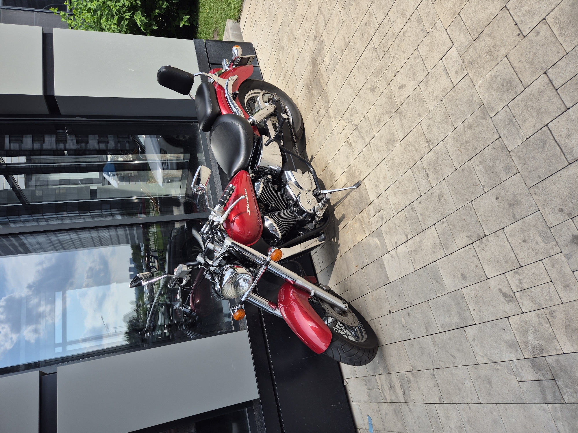 Red Honda Shadow parked outside modern building in Voronezh