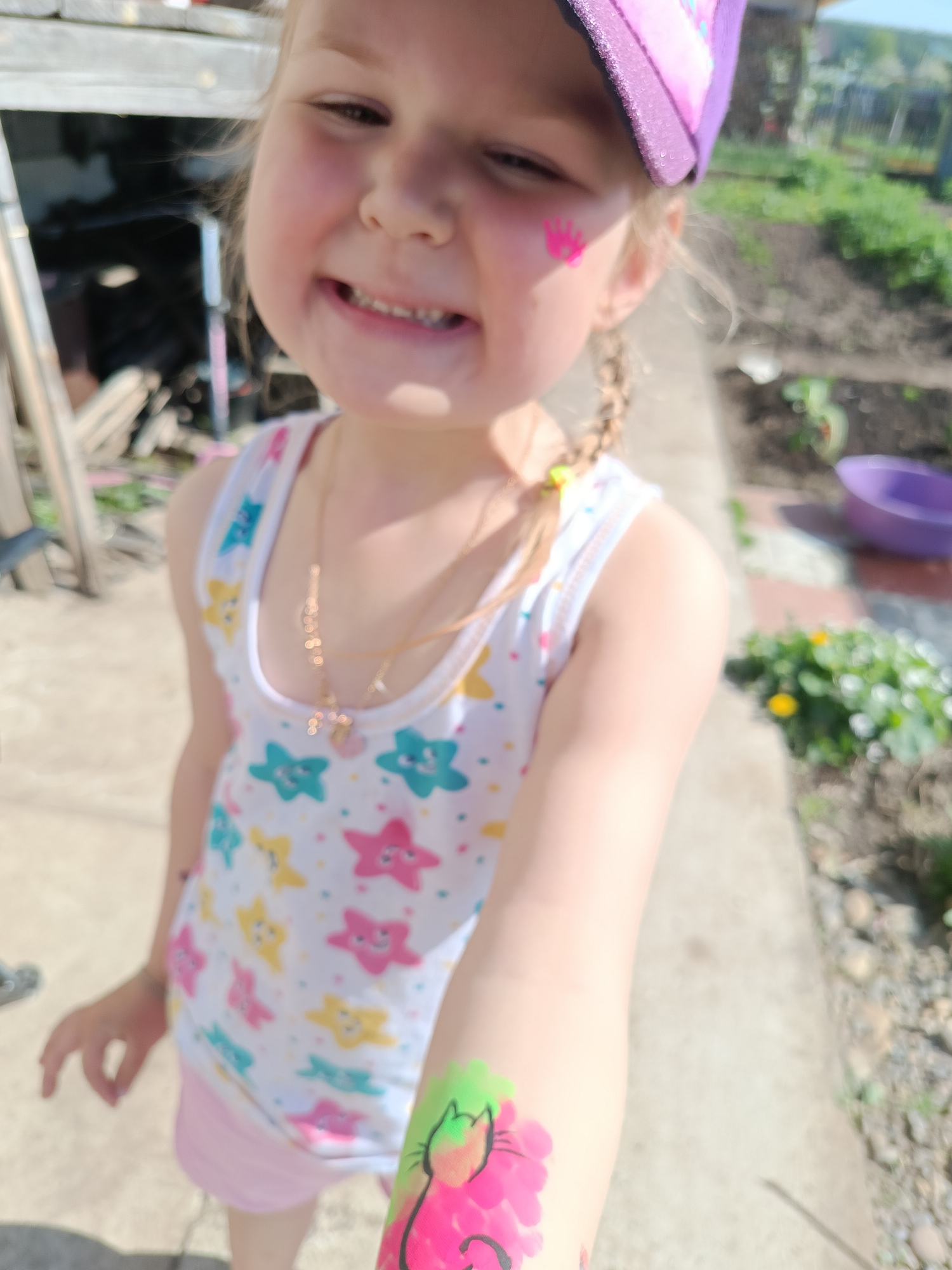Girl with pink crown, cat face paint smiles for camera