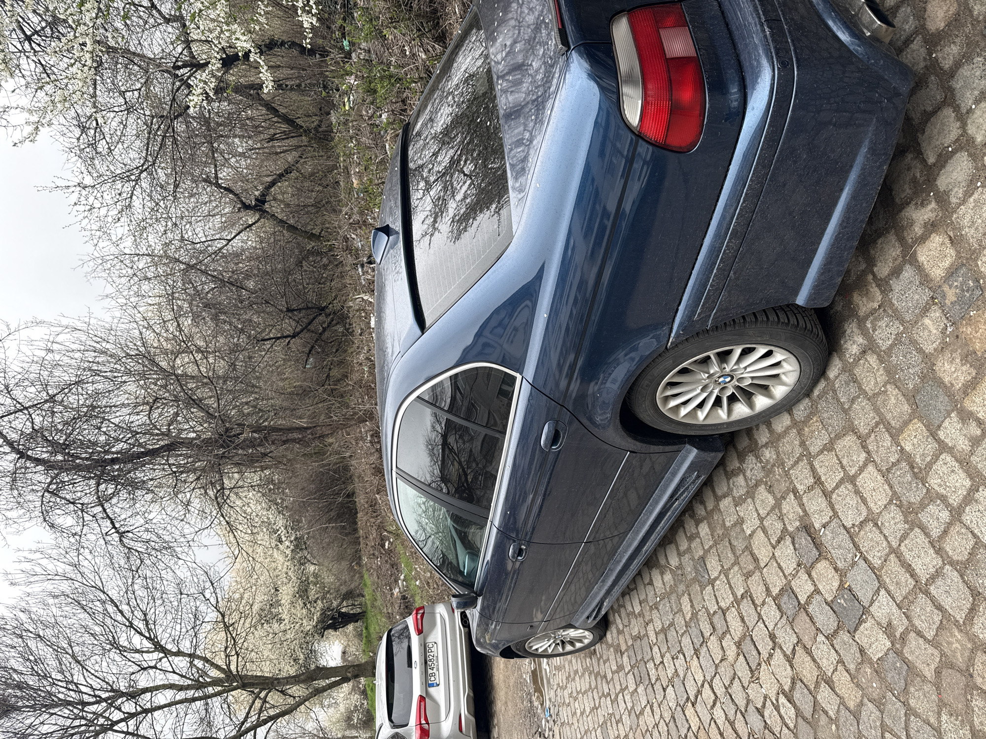 Blue BMW parked on cobblestone street in Sofia