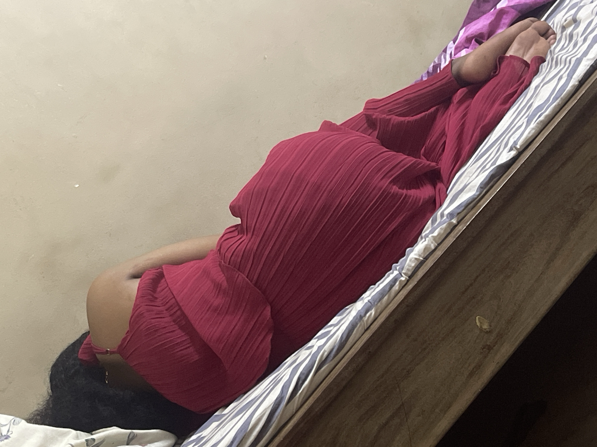 Resting on a striped bed in a Dar es Salaam bedroom