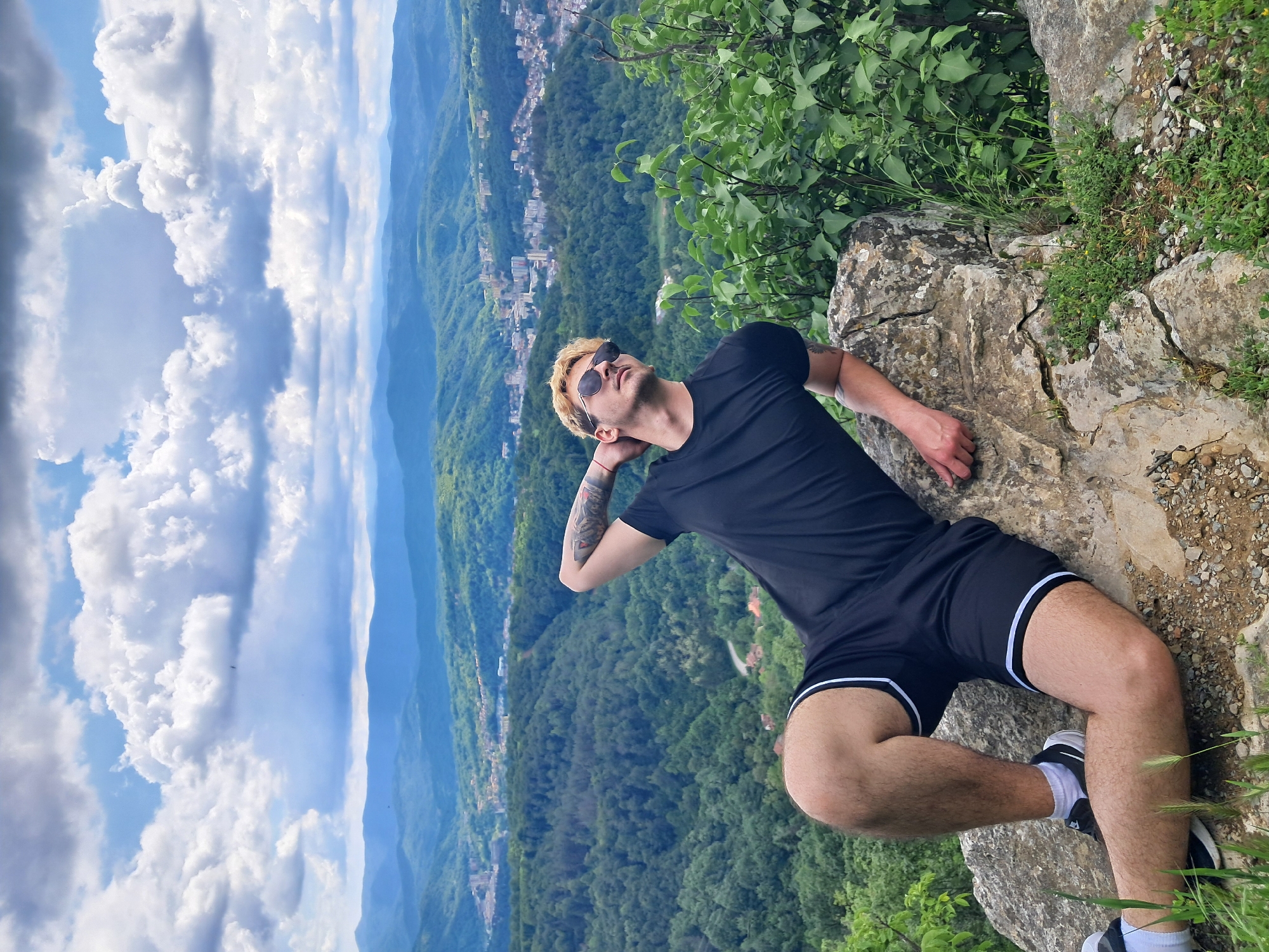 Three men sightsee from rocky outcrop overlooking Gabrovo valley