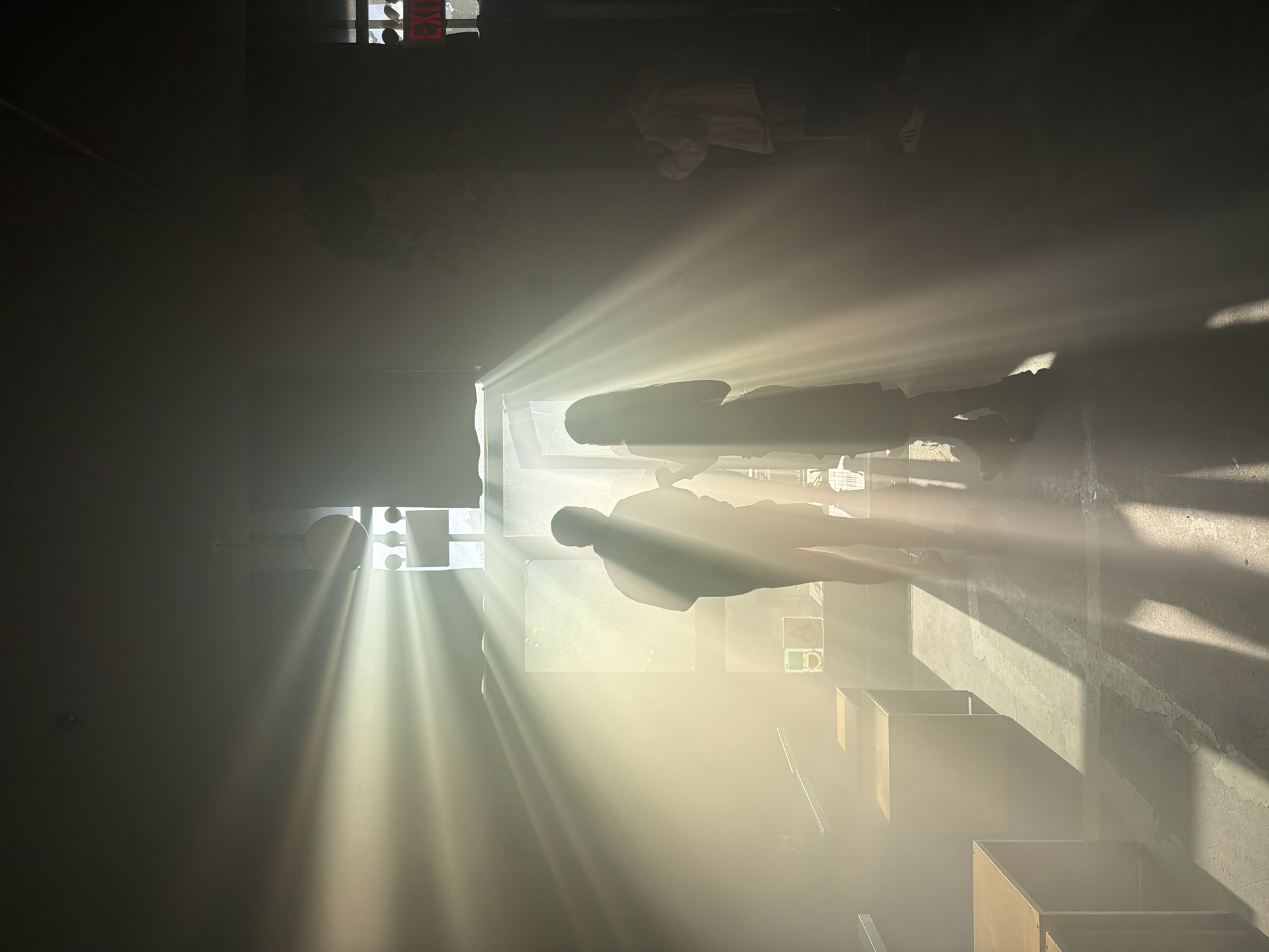 Dramatic sunbeams illuminate darkened NYC interior space