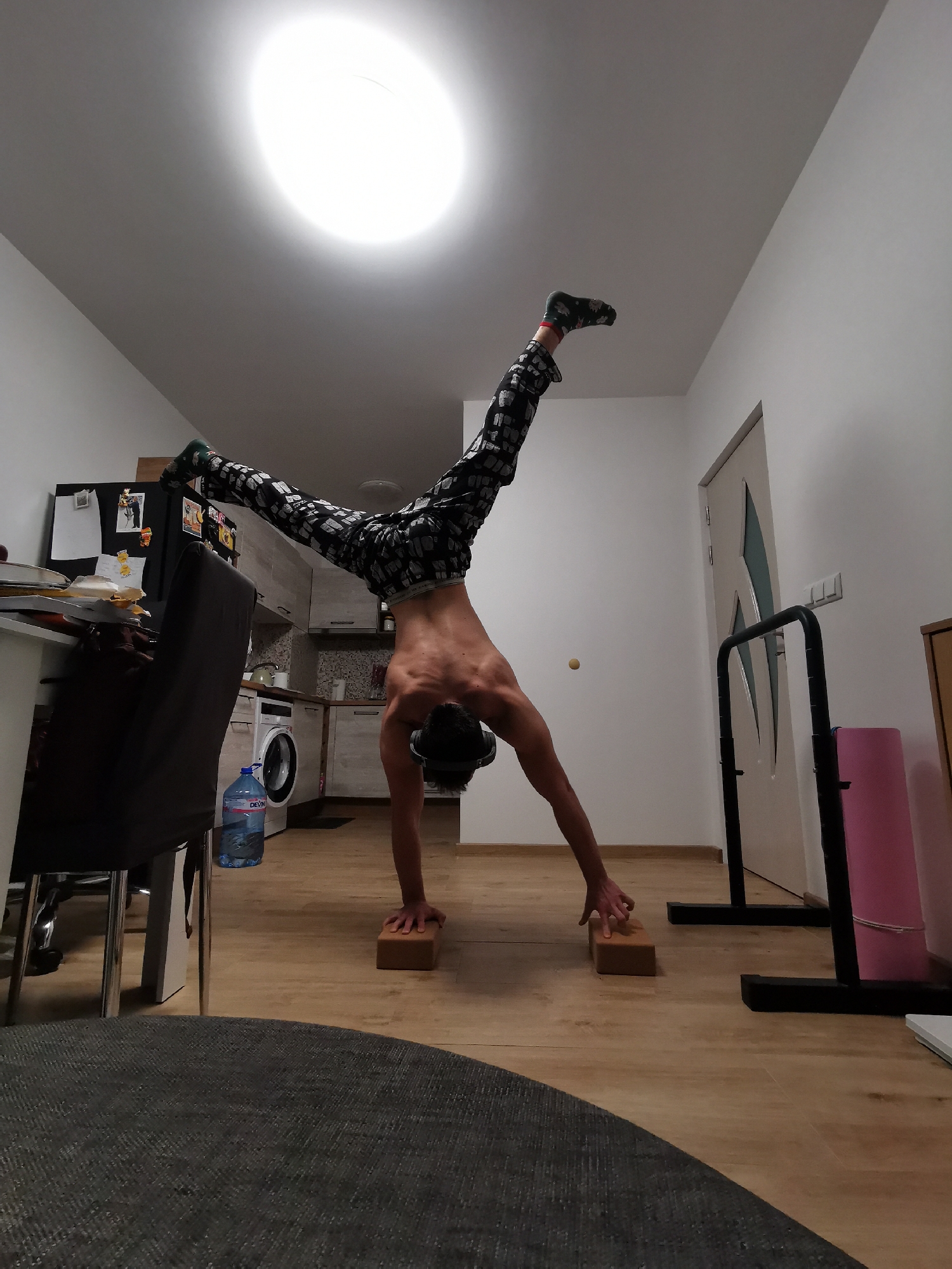 Person performs handstand exercise on blocks at home