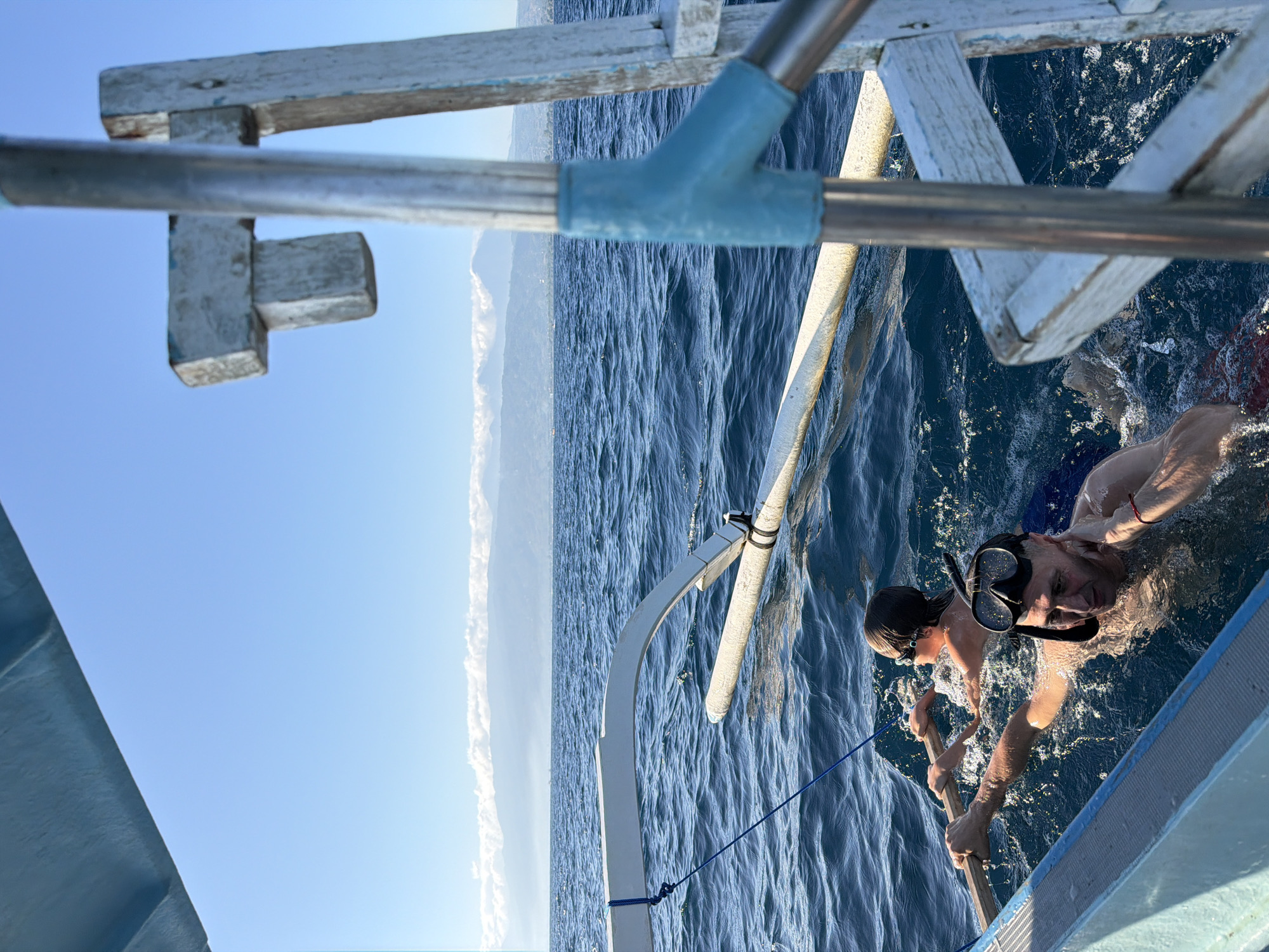 Swimming and drifting near an outrigger boat off the Indonesian coast