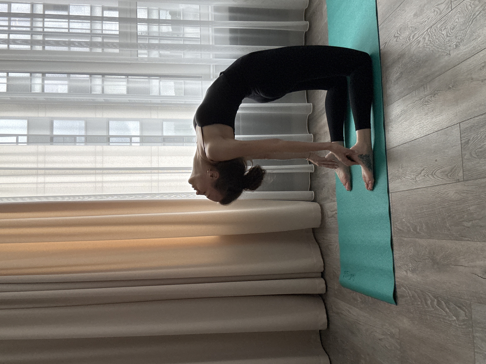 Morning yoga flow by a window overlooking city high-rises