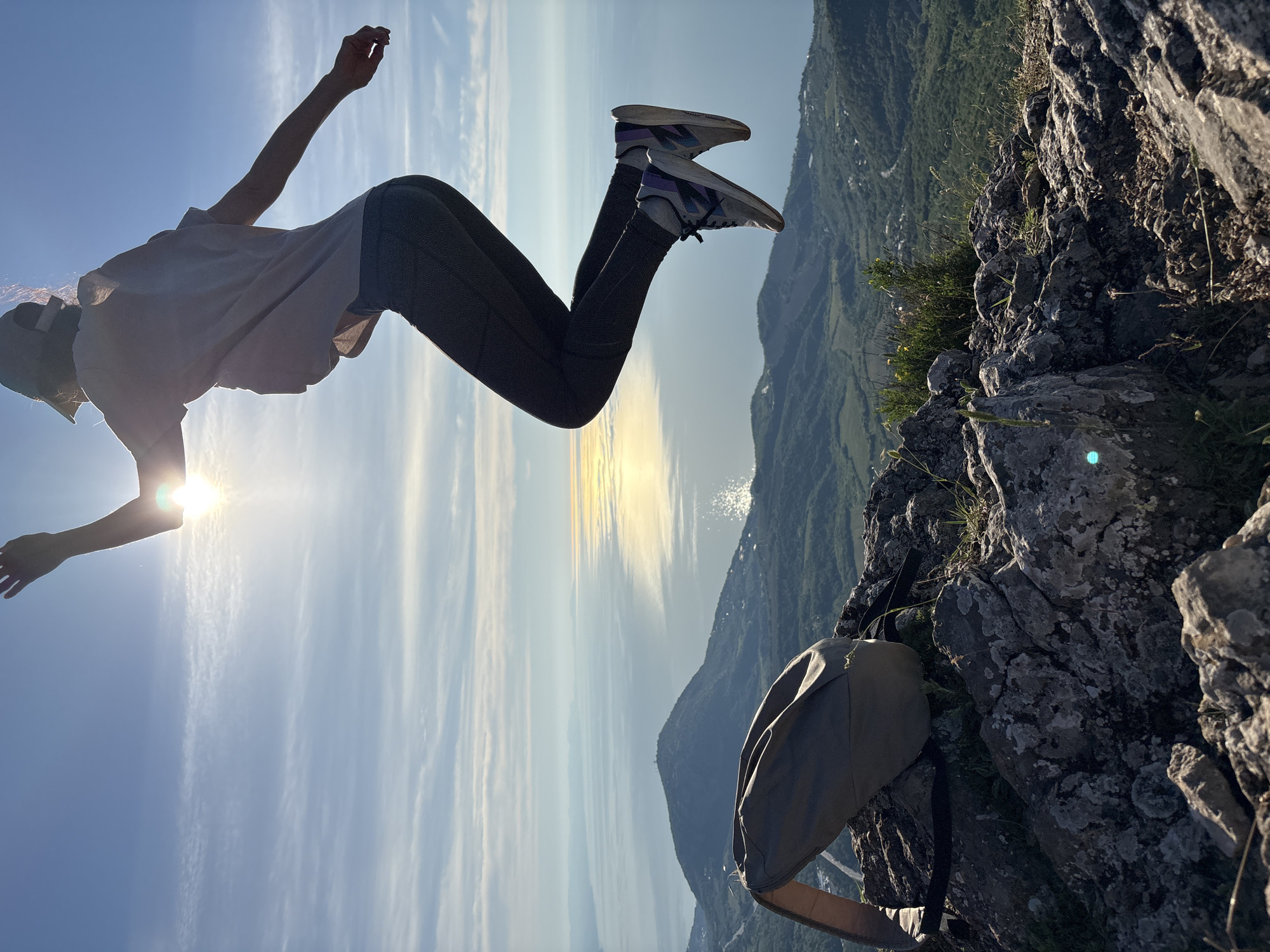 Person captured jumping on mountain peak overlooking coast