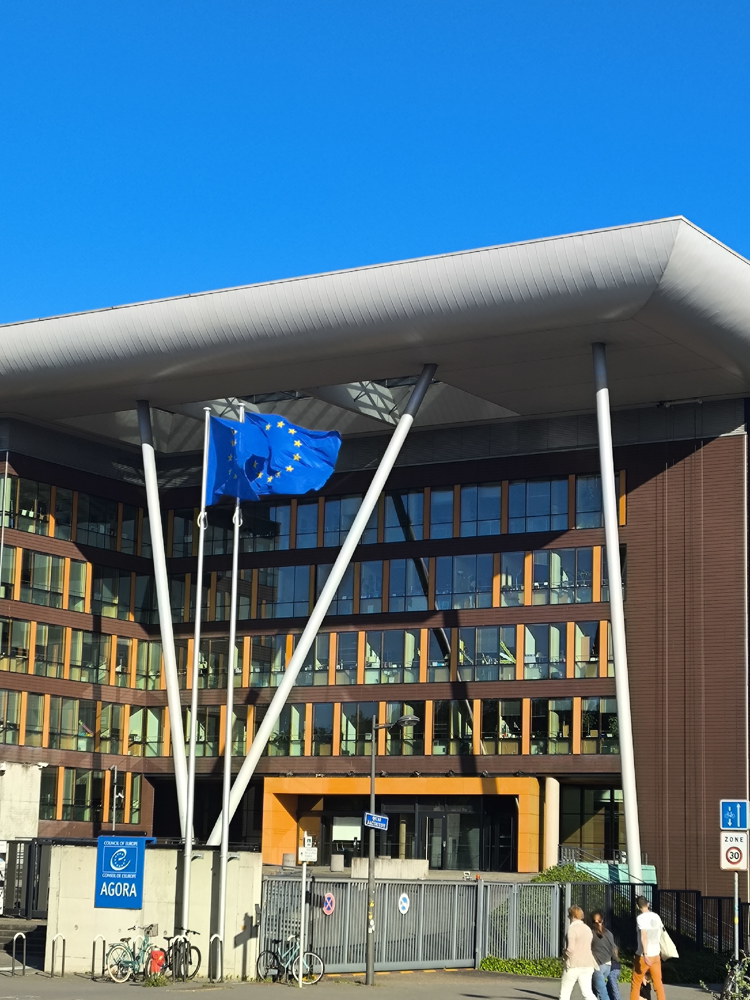 Tourist documents European Parliament buildings, pedestrians in Strasbourg