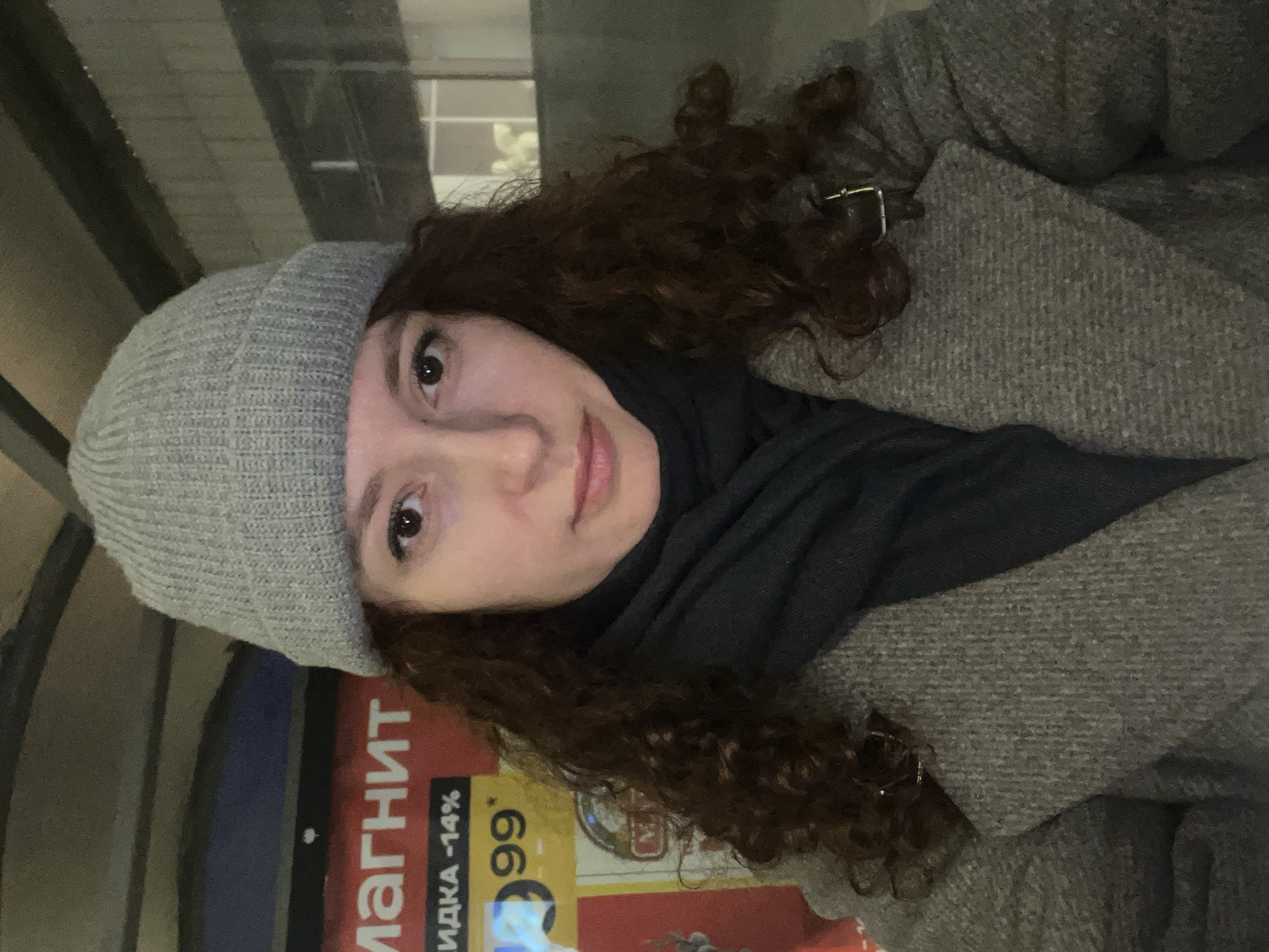 Woman takes selfie near store in rainy Saint Petersburg