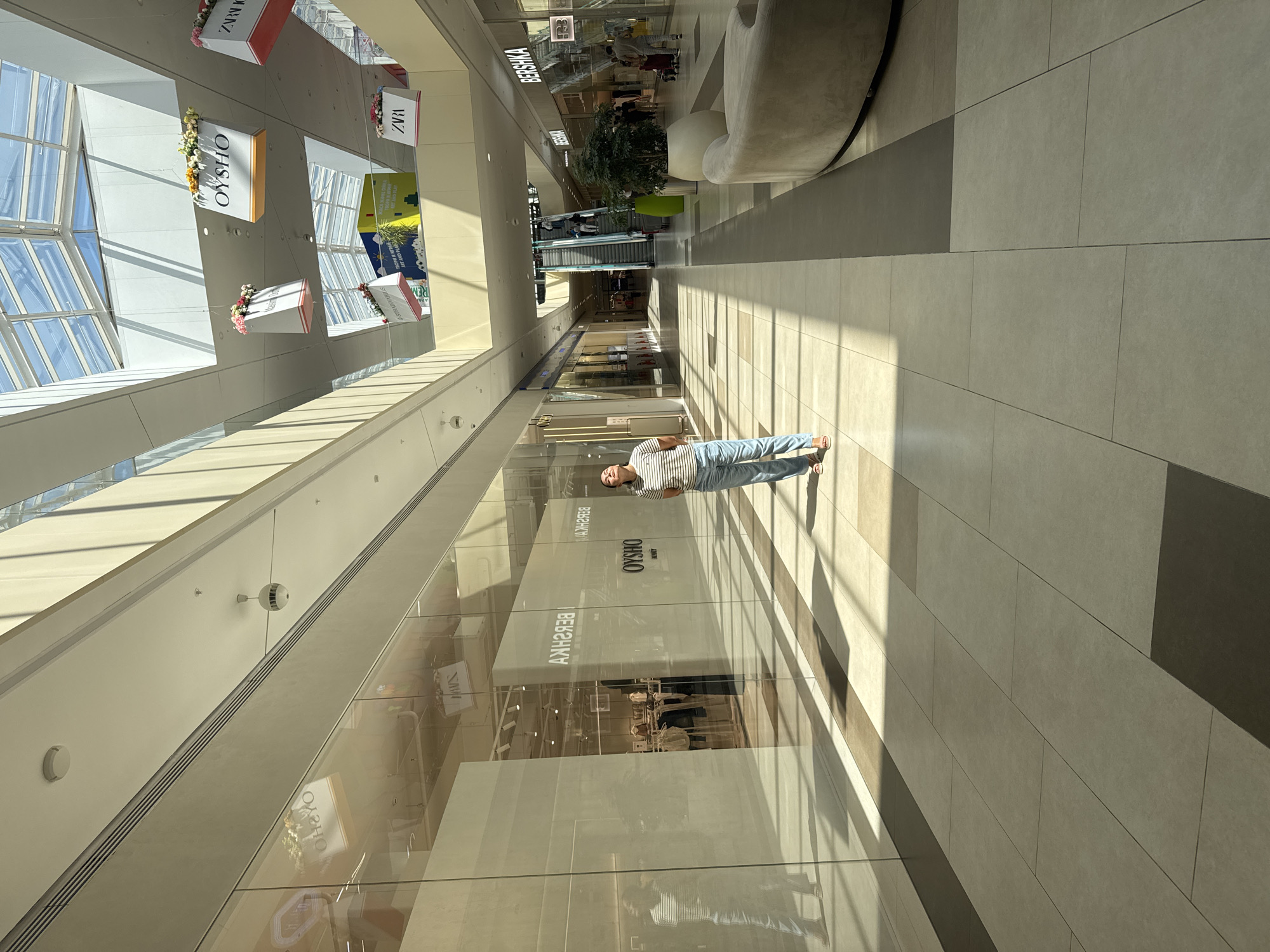 Inside and outside a modern Almaty mall, Alatau mountains backdrop