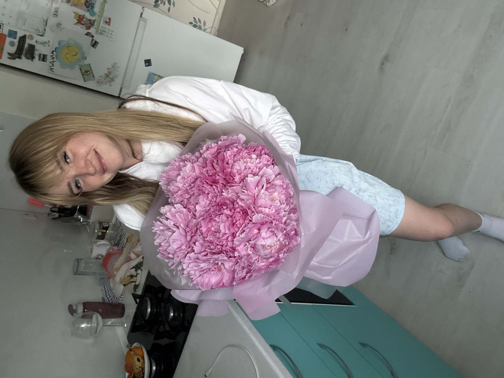 Pink peonies, fresh strawberries, and fritters at home in Russia