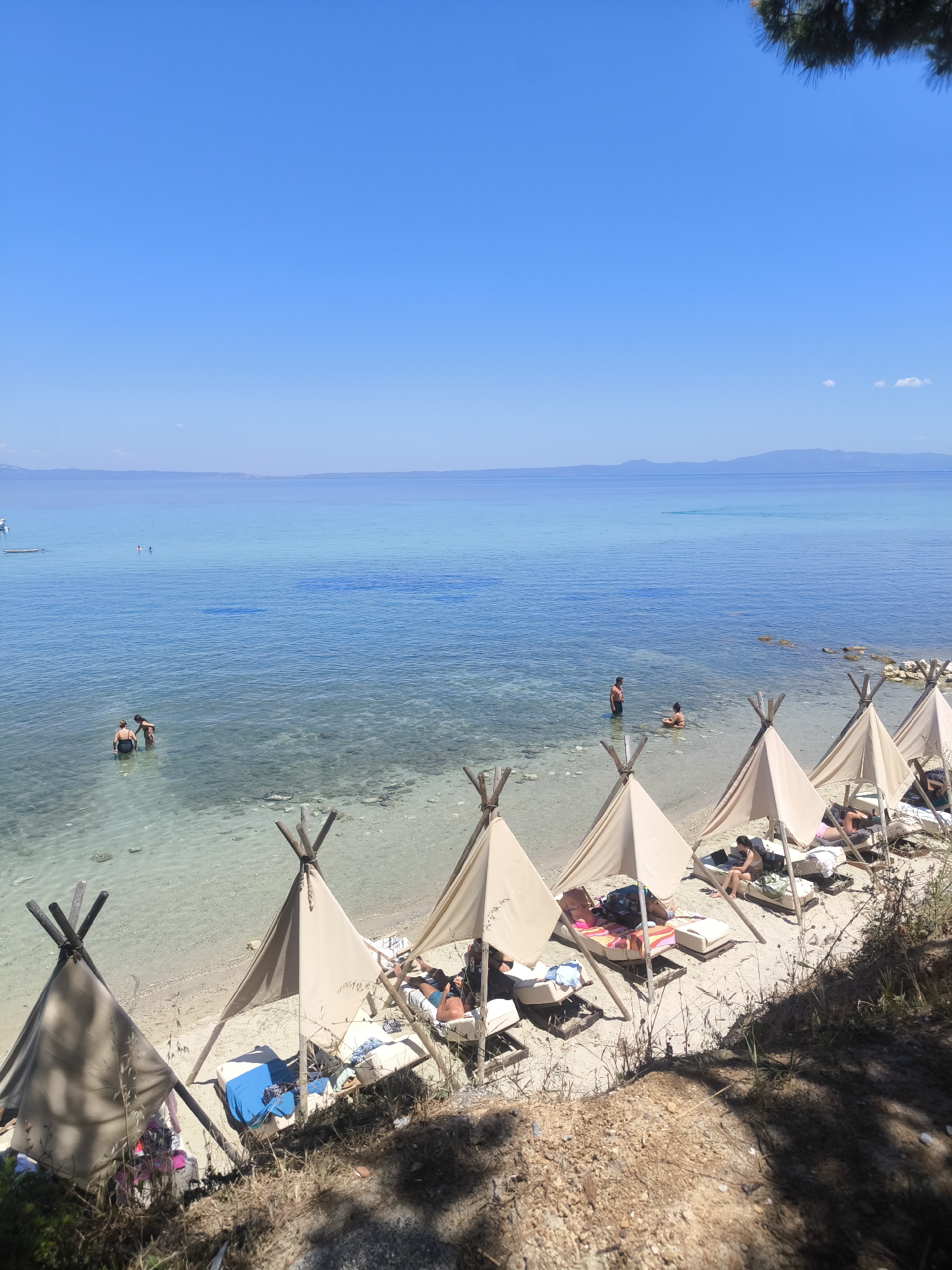 Quiet beach setup with conical tents on Kassandra's shore