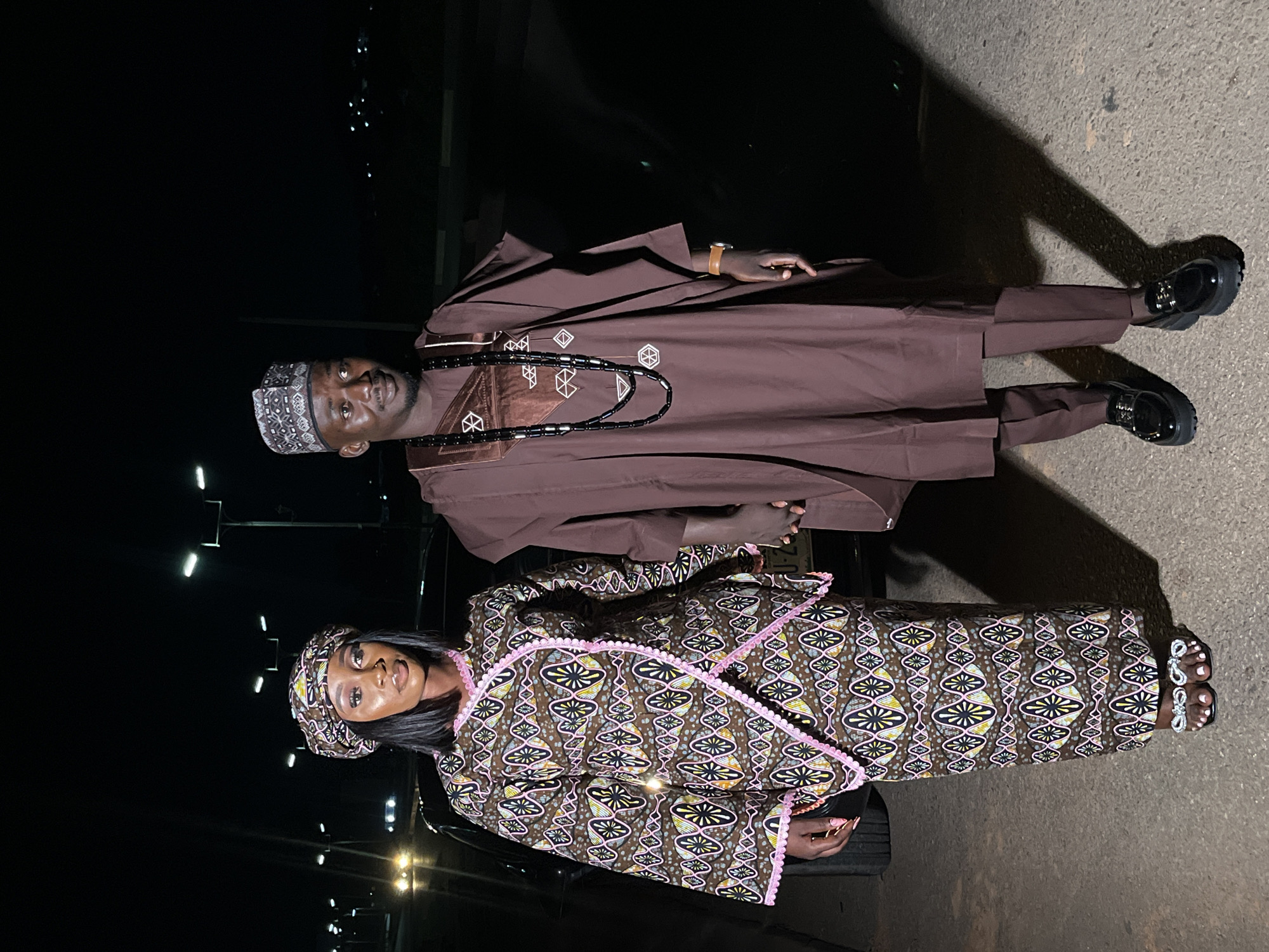 Couple in matching traditional outfits poses at night in Gura Top